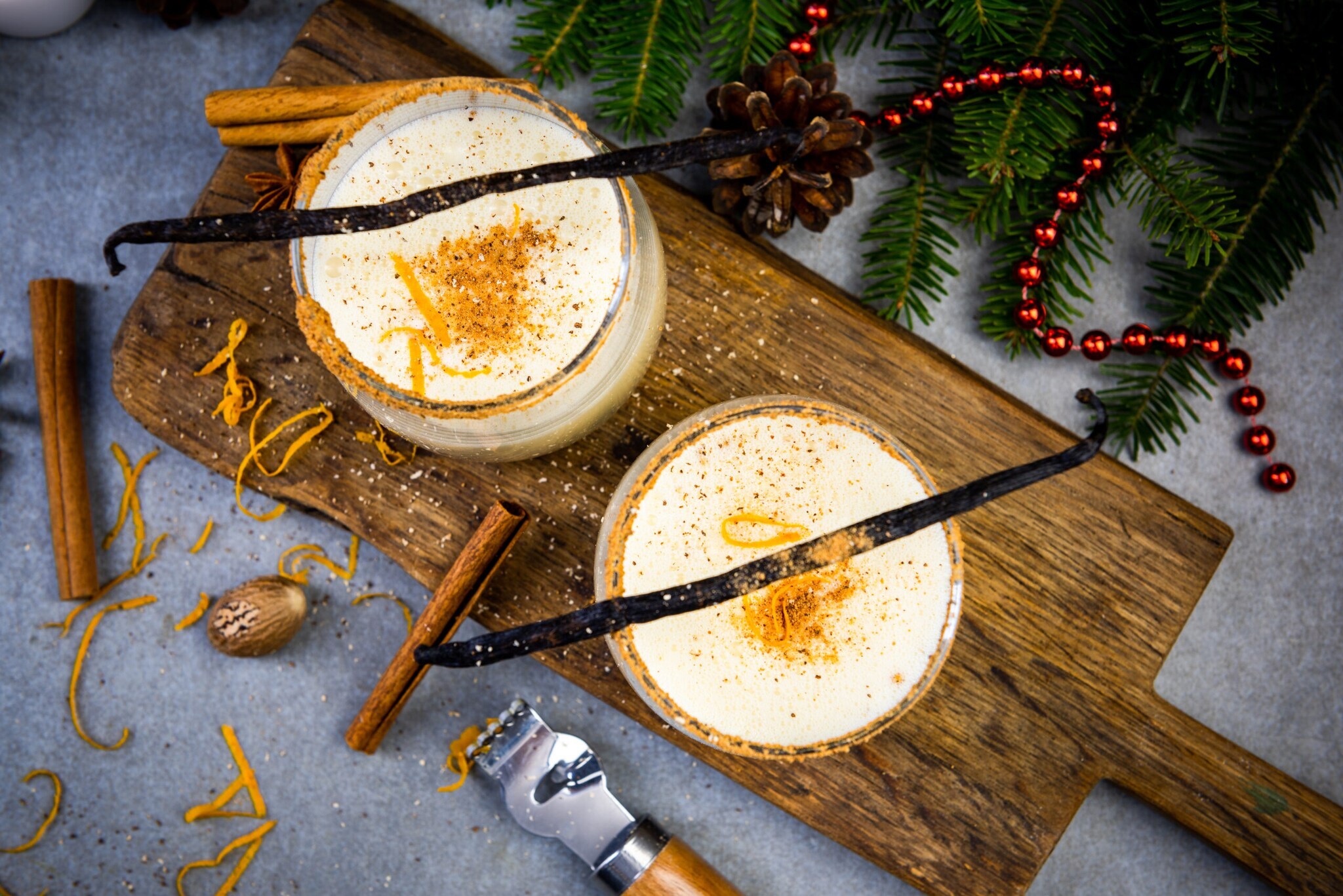 Zwei Gläser mit einem weihnachtlichen Heißgetränk mit Milch, Sahne, Zimt, Vanille, Muskat und Sahne, weihnachtlich dekoriert Zwei Gläser mit einem weihnachtlichen Heißgetränk mit Milch, Sahne, Zimt, Vanille, Muskat und Sahne, weihnachtlich dekoriert