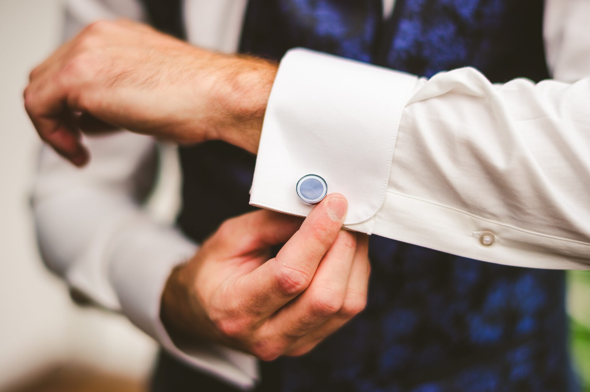 Ein Mann knöpft die Manschettenknöpfe an seinem Hemd