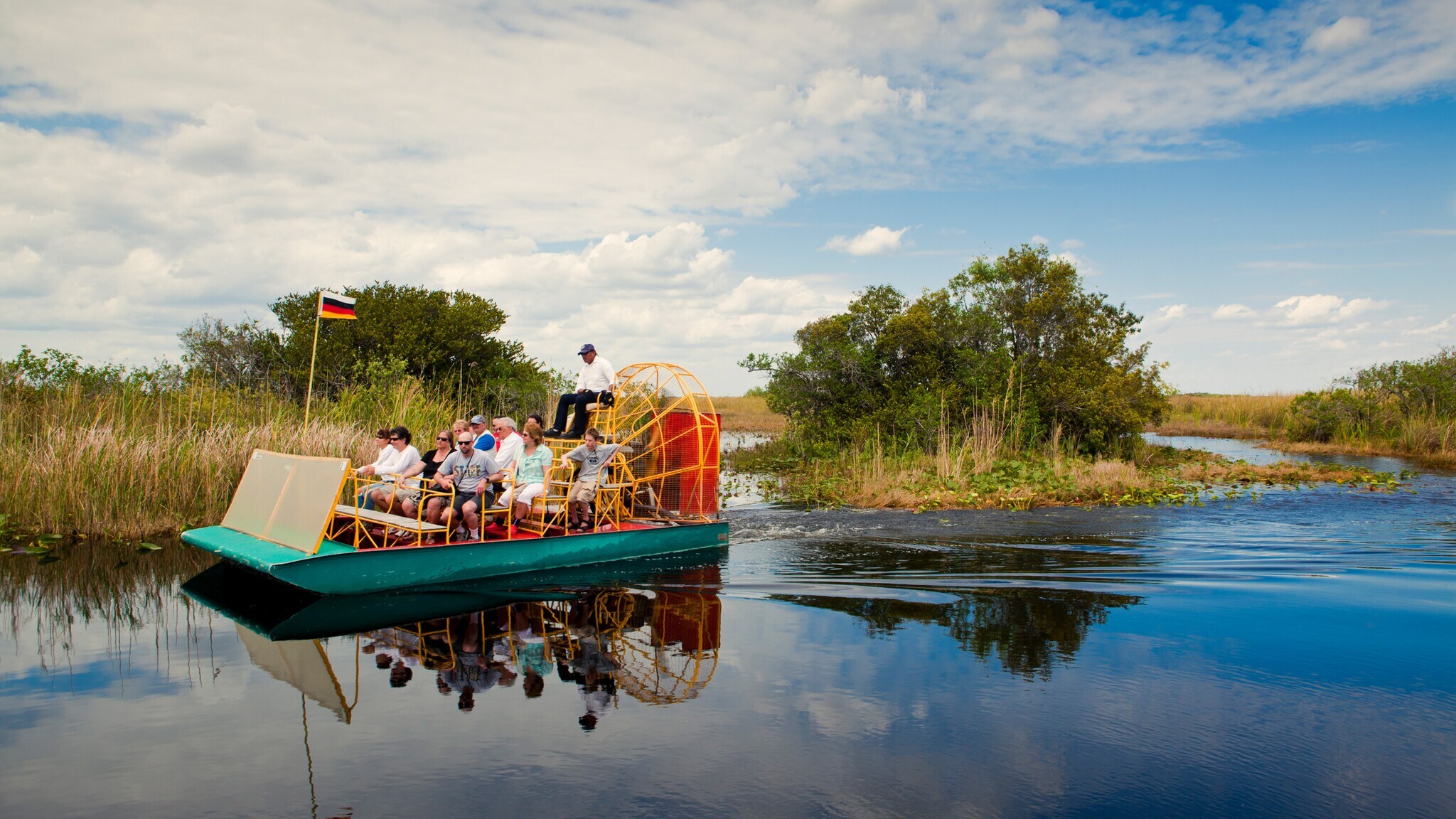Personen auf einem Airboat in einem Sumpfgebiet.