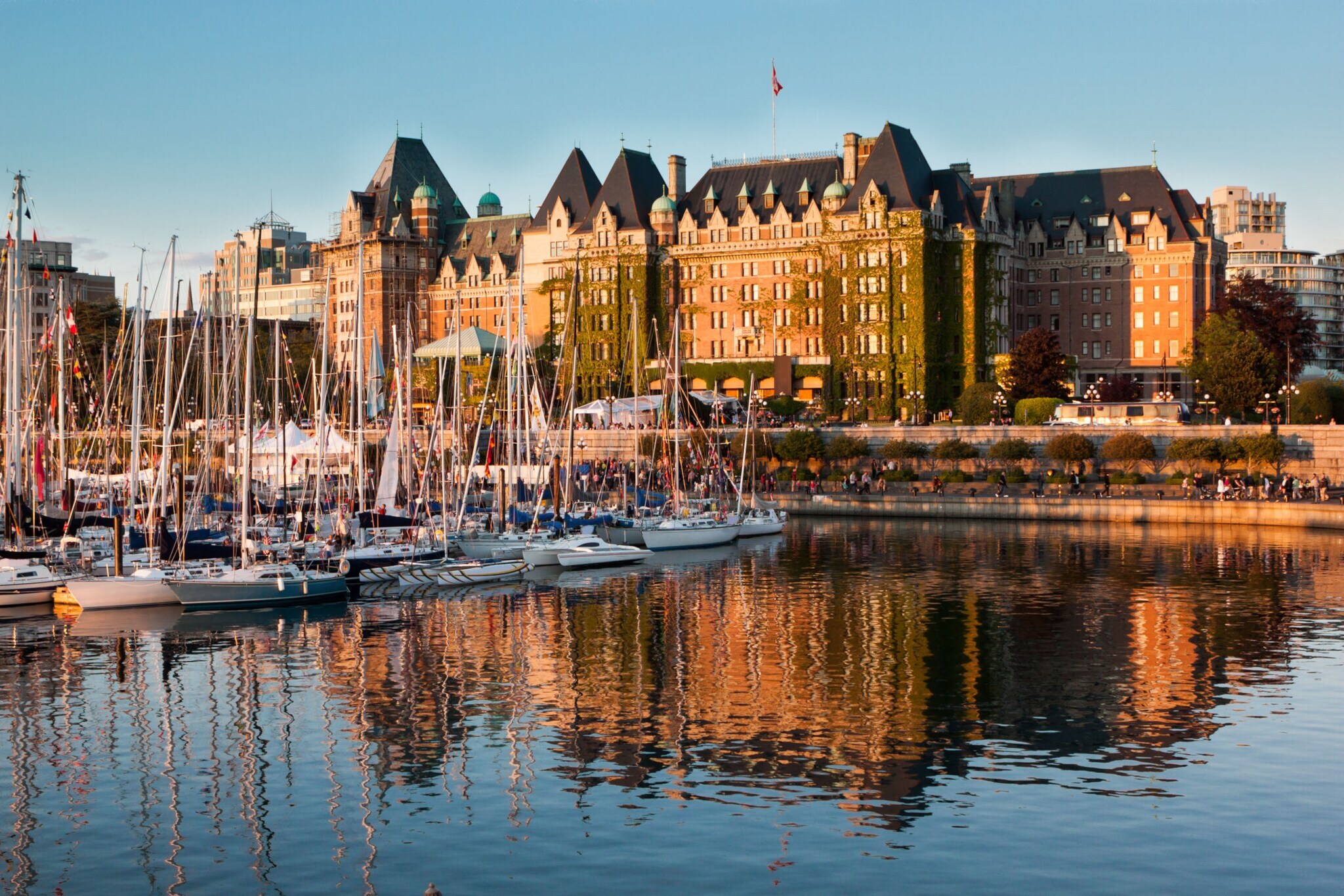 Boote vor dem historischen Fairmont Empress Hotel im Inner Harbour an einem klaren sonnigen Tag.