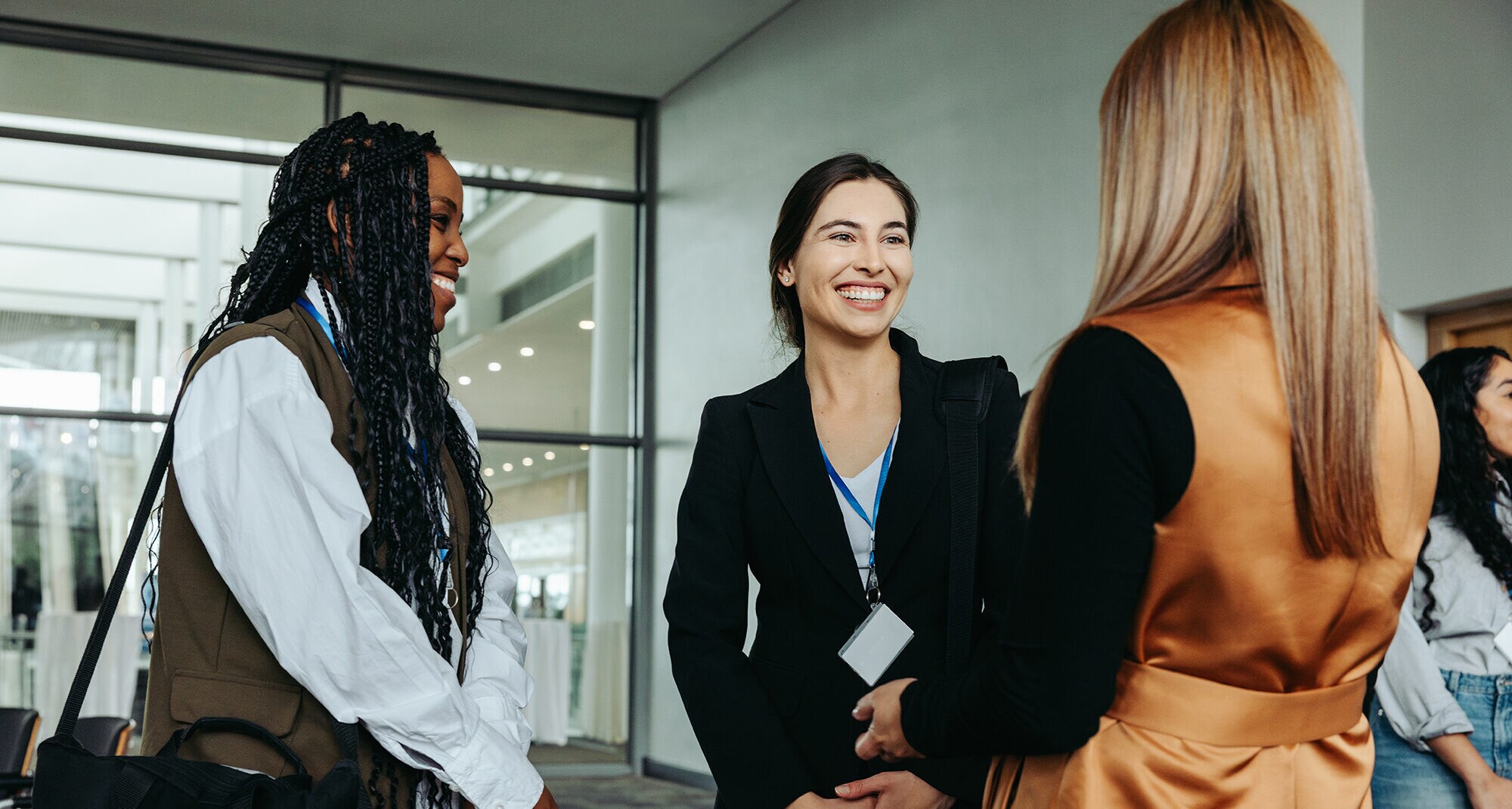 3 junge Geschäftsfrauen unterhalten sich während einer Konferenz