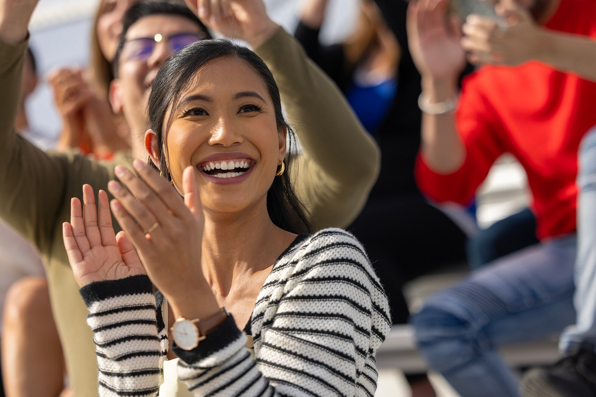 Relaxen und VIP-Extras genießen: Bei Kunst-, Kultur-, Sport- und Gourmet-Events Eine junge Frau jubelt bei einer Sportveranstaltung.