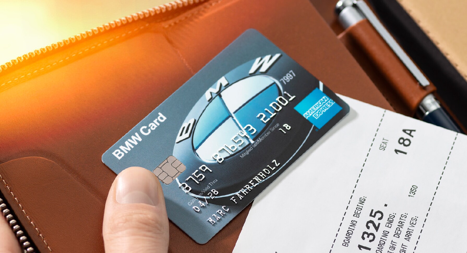 Eine BMW Kreditkarte von American Express auf einem Lederetui, gehalten von einer Hand.
