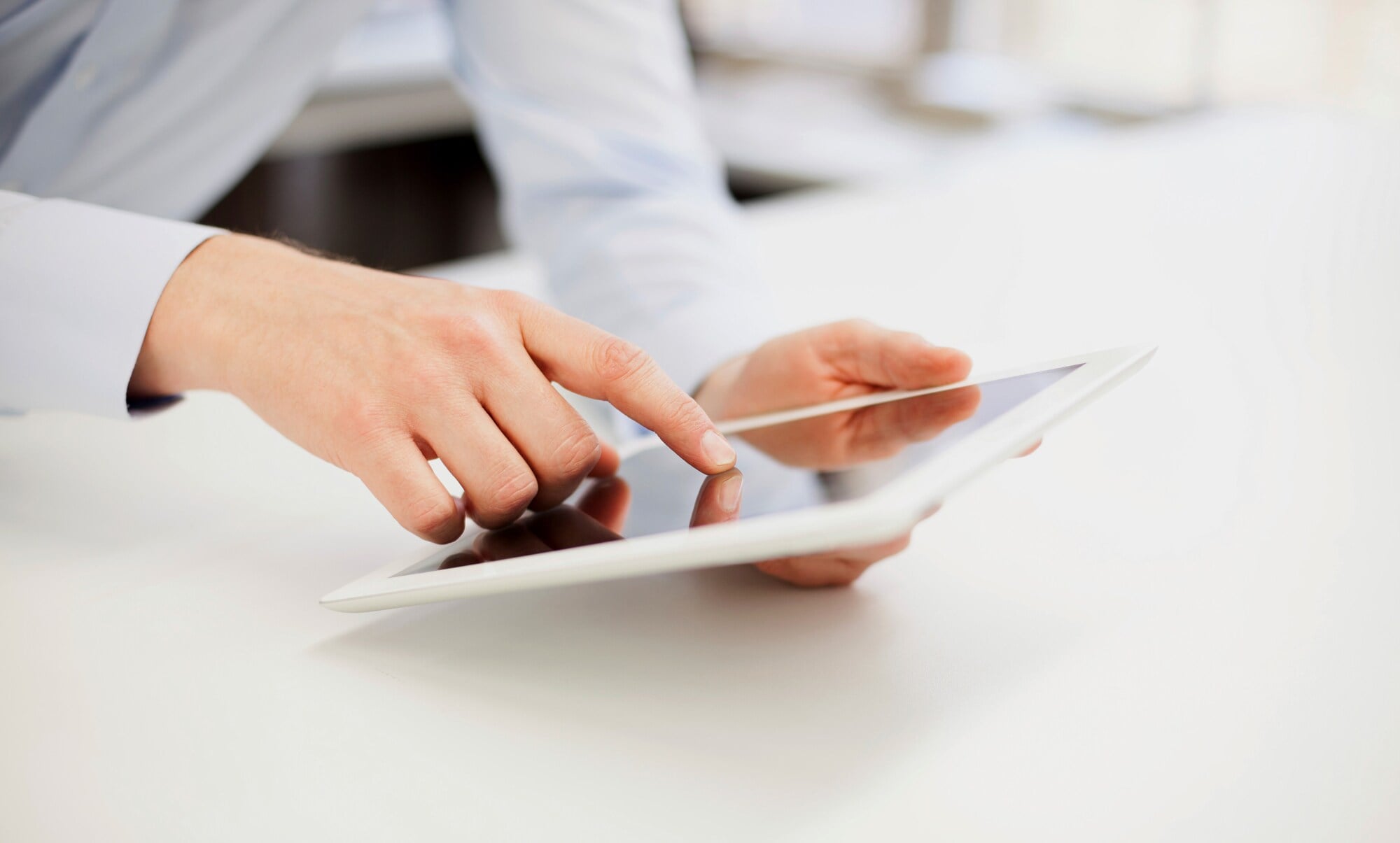 Eine Hand bedient ein weißes Tablet Eine Hand bedient ein weißes Tablet