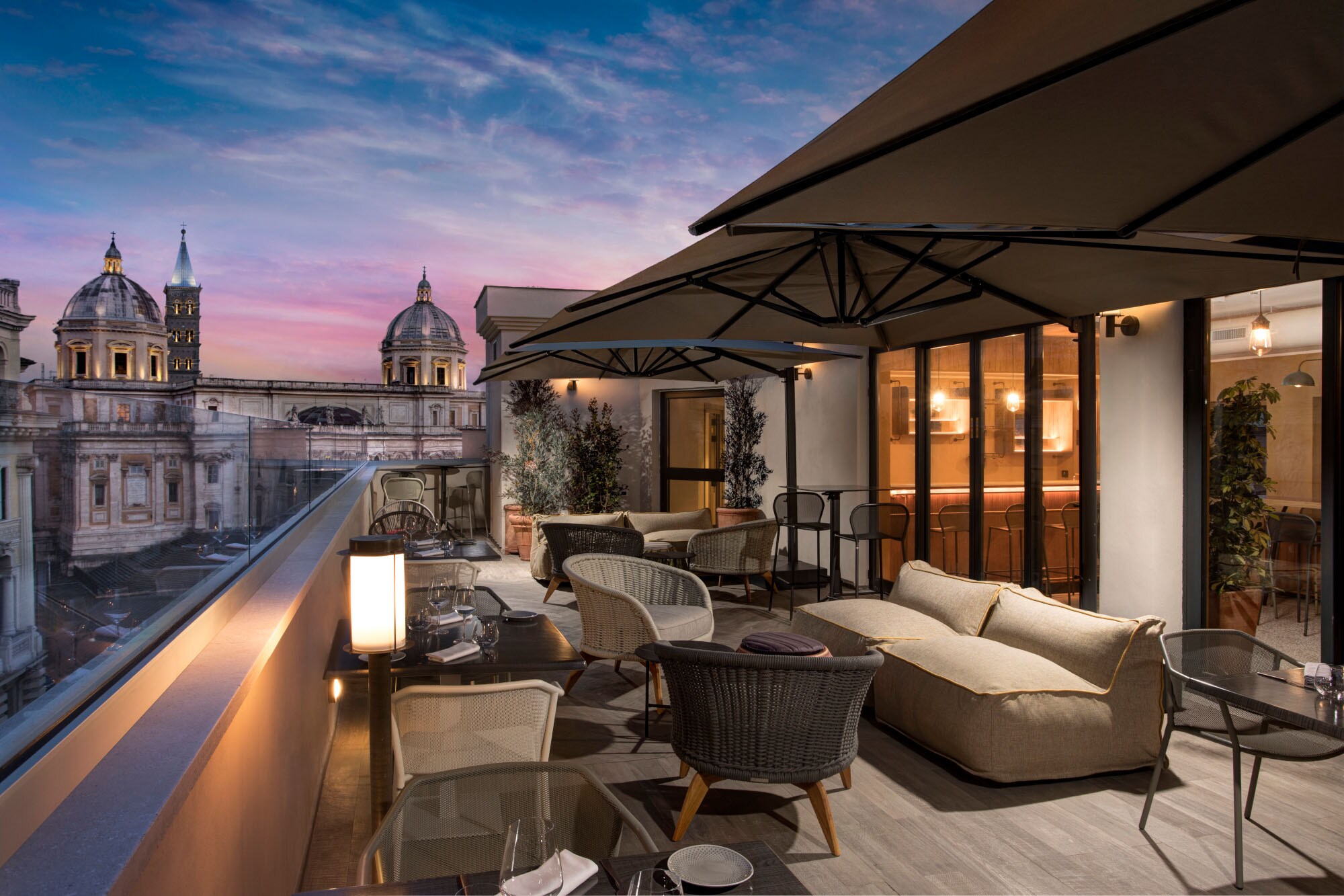 Terrasse eines modernen, eleganten Hotels mit Sitzgelegenheiten im Stadtzentrum Roms bei Abenddämmerung Terrasse eines modernen, eleganten Hotels mit Sitzgelegenheiten im Stadtzentrum Roms bei Abenddämmerung