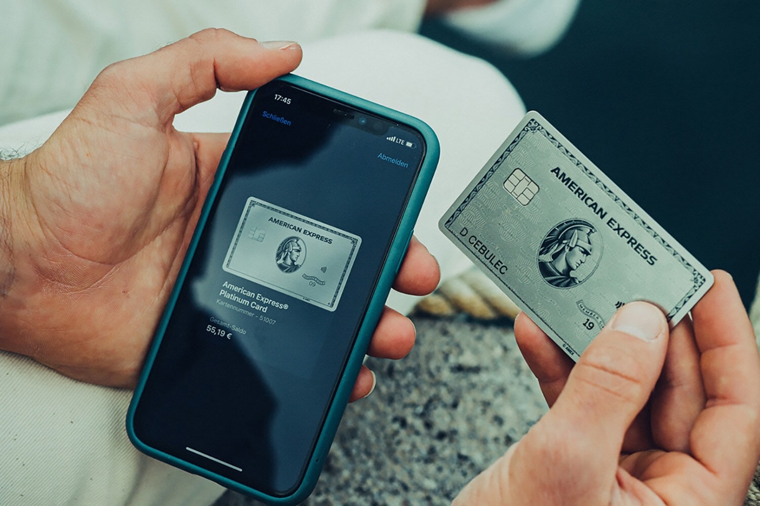 Eine Amex Kreditkarte wird neben ein Smartphone mit Apple Pay gehalten Eine Amex Platinum Kreditkarte wird neben ein Smartphone mit Apple Pay gehalten.
