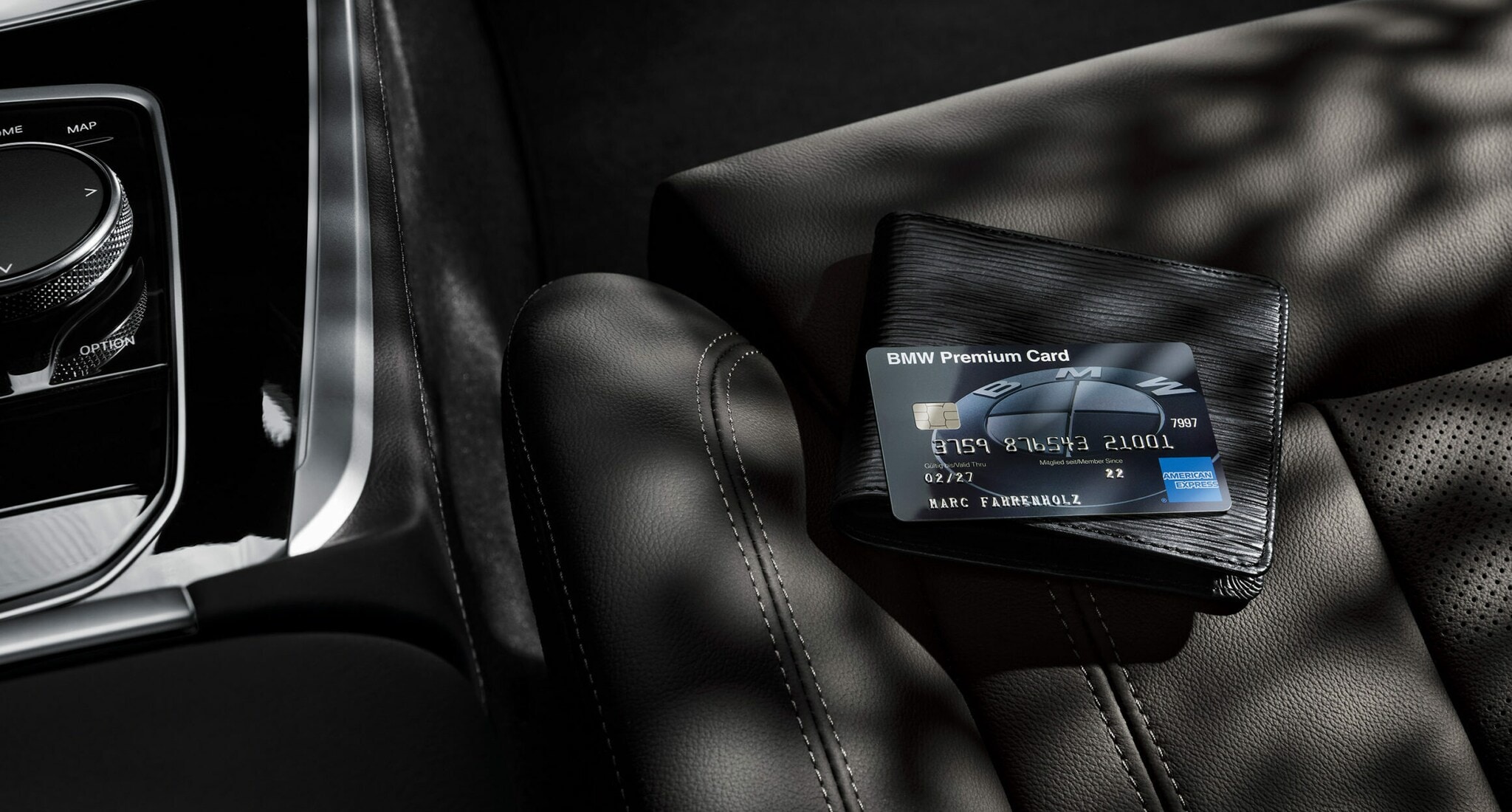 Eine schwarze BMW Premium Card von American Express liegt auf einem schwarzen Portemonnaie auf einem schwarzen Autositz aus Leder Eine schwarze BMW Premium Card von American Express liegt auf einem schwarzen Portemonnaie auf einem schwarzen Autositz aus Leder
