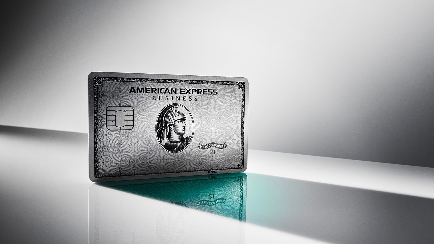 Eine aufgestellte Business Platinum Card von American Express auf einer spiegelnden Fläche vor grauem Hintergrund mit Lichtverlauf. Eine aufgestellte Business Platinum Card von American Express auf einer spiegelnden Fläche vor grauem Hintergrund mit Lichtverlauf.