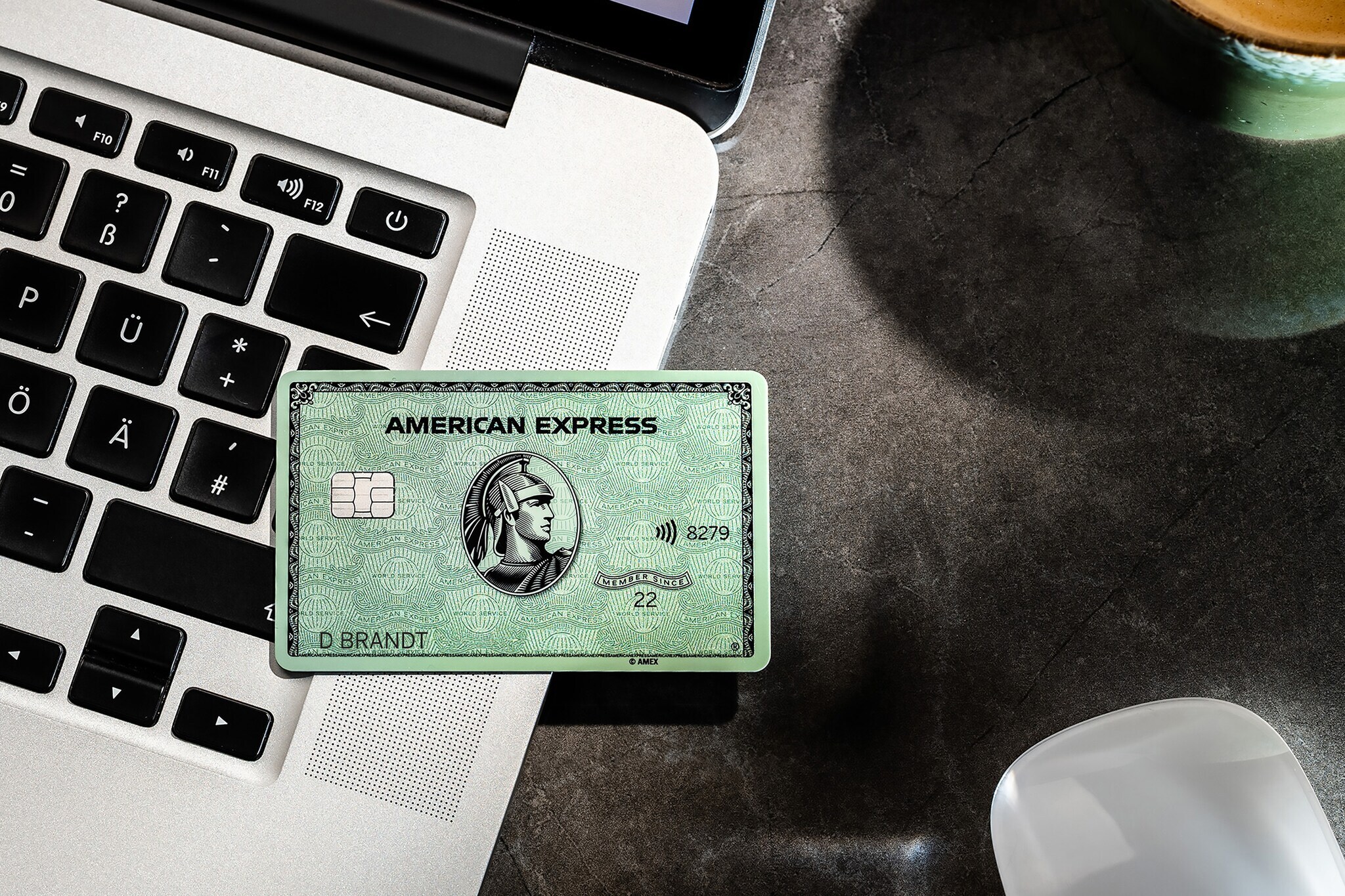 Eine American Express Card mit vierstelliger Prüfnummer liegt auf einem Laptop.