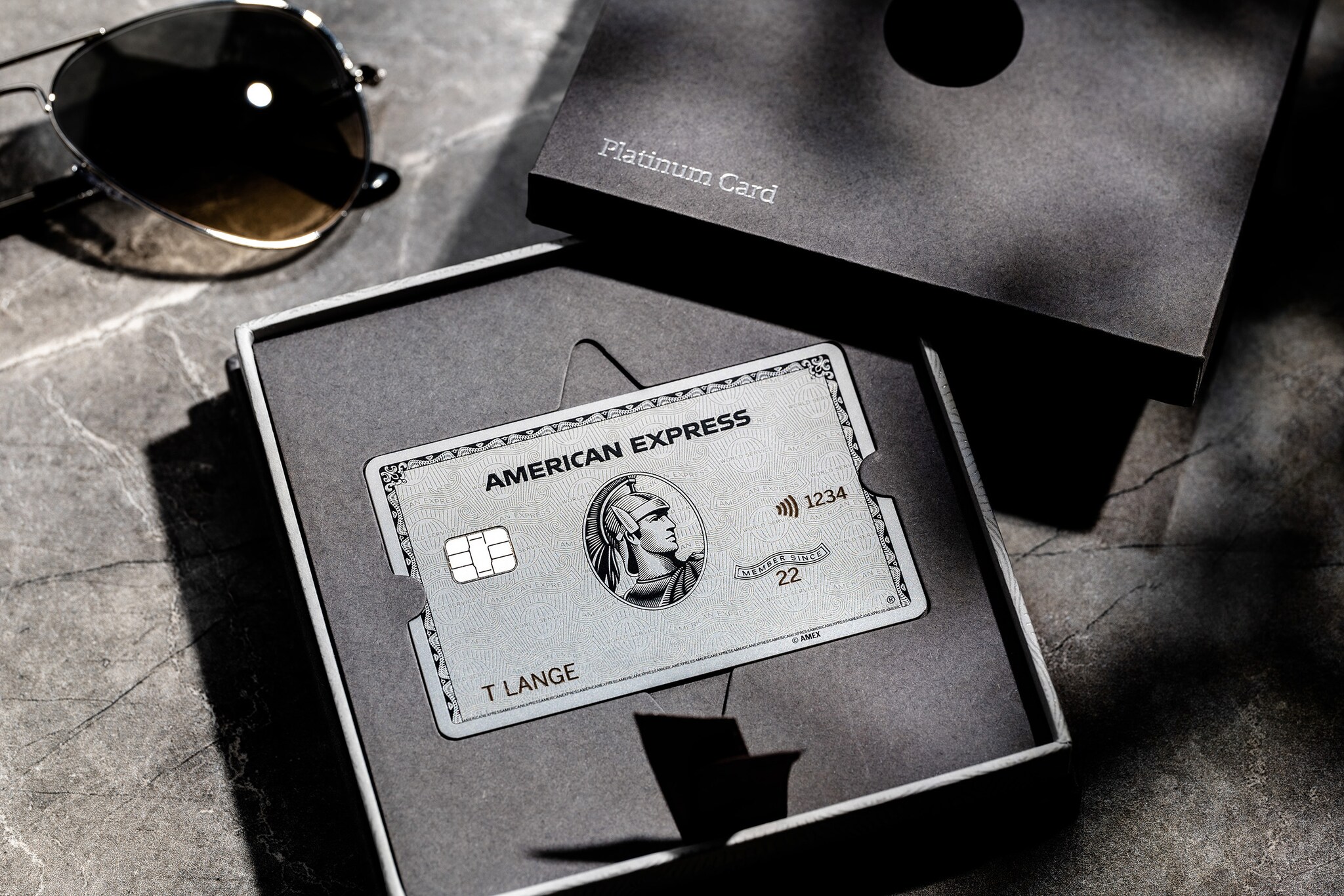 Eine silberne Platinum Card von Ameican Express in einer Präsentationsbox aus grauer Feinkartonage.