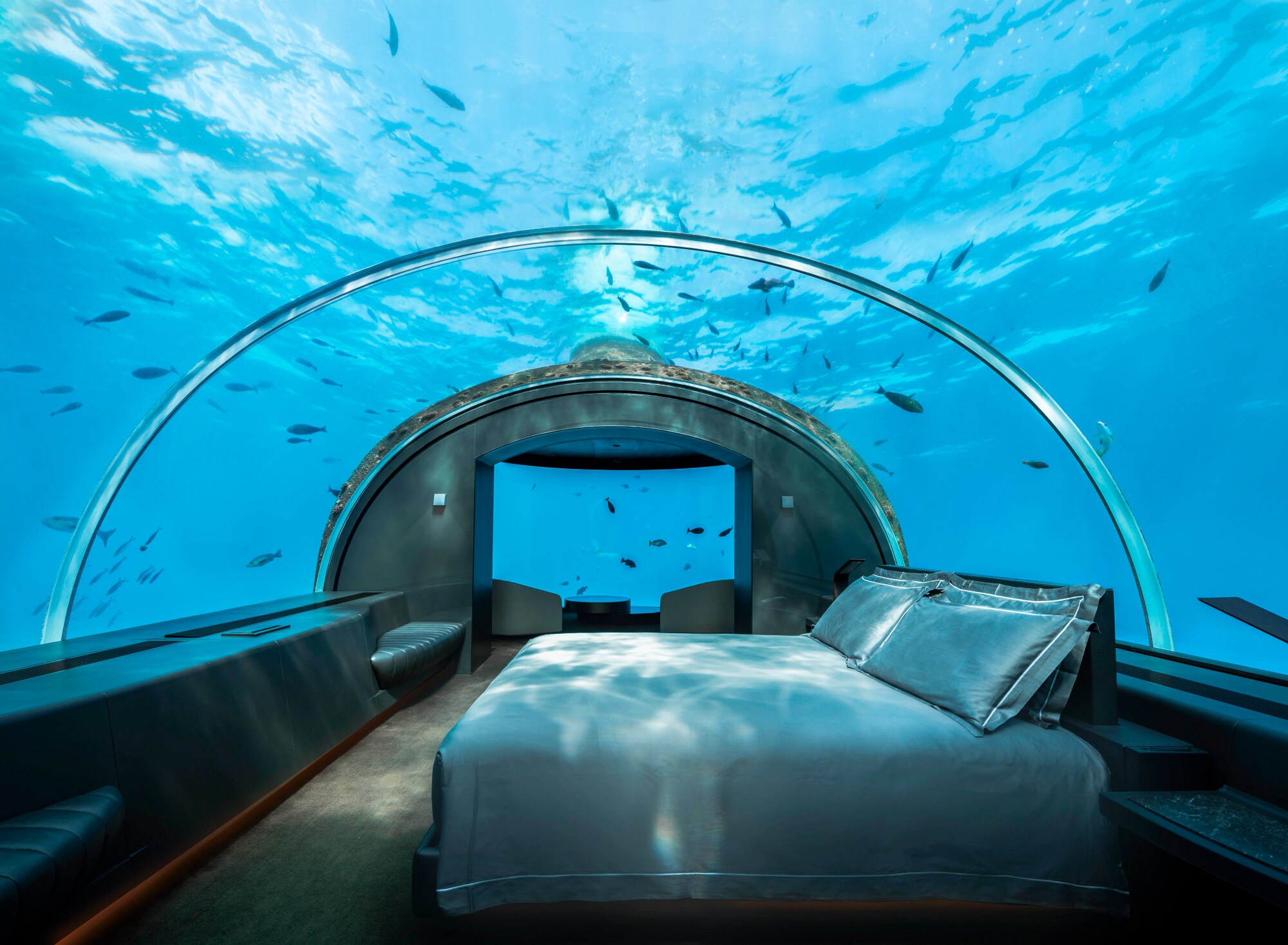Eine Unterwasserhotelsuite mit Glaskuppel, an der Fische vorbeischwimmen. Eine Unterwasserhotelsuite mit Glaskuppel, an der Fische vorbeischwimmen.