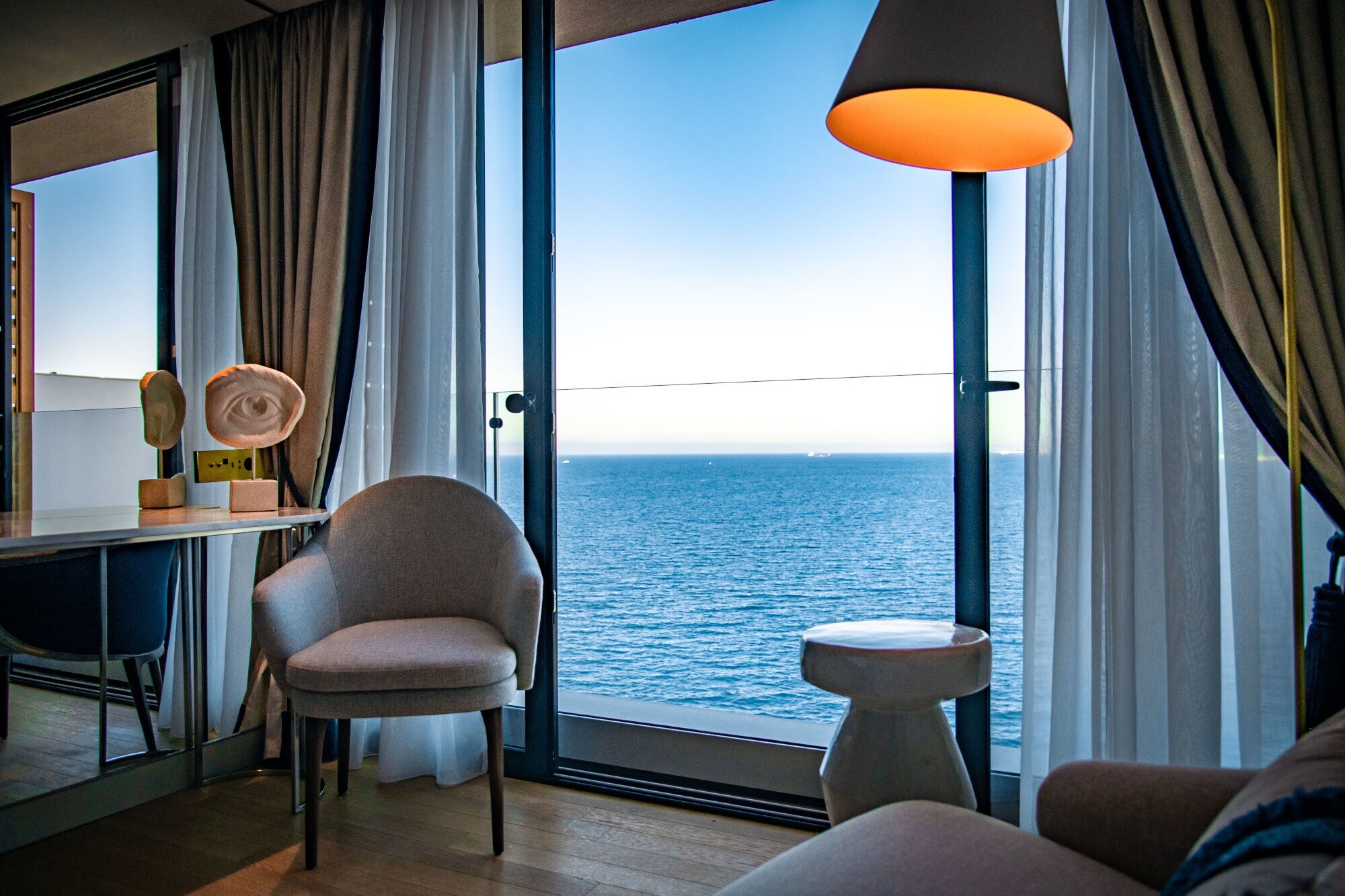 Elegantes Hotelzimmer mit bodentiefem Fenster am Meer Elegantes Hotelzimmer mit bodentiefem Fenster am Meer