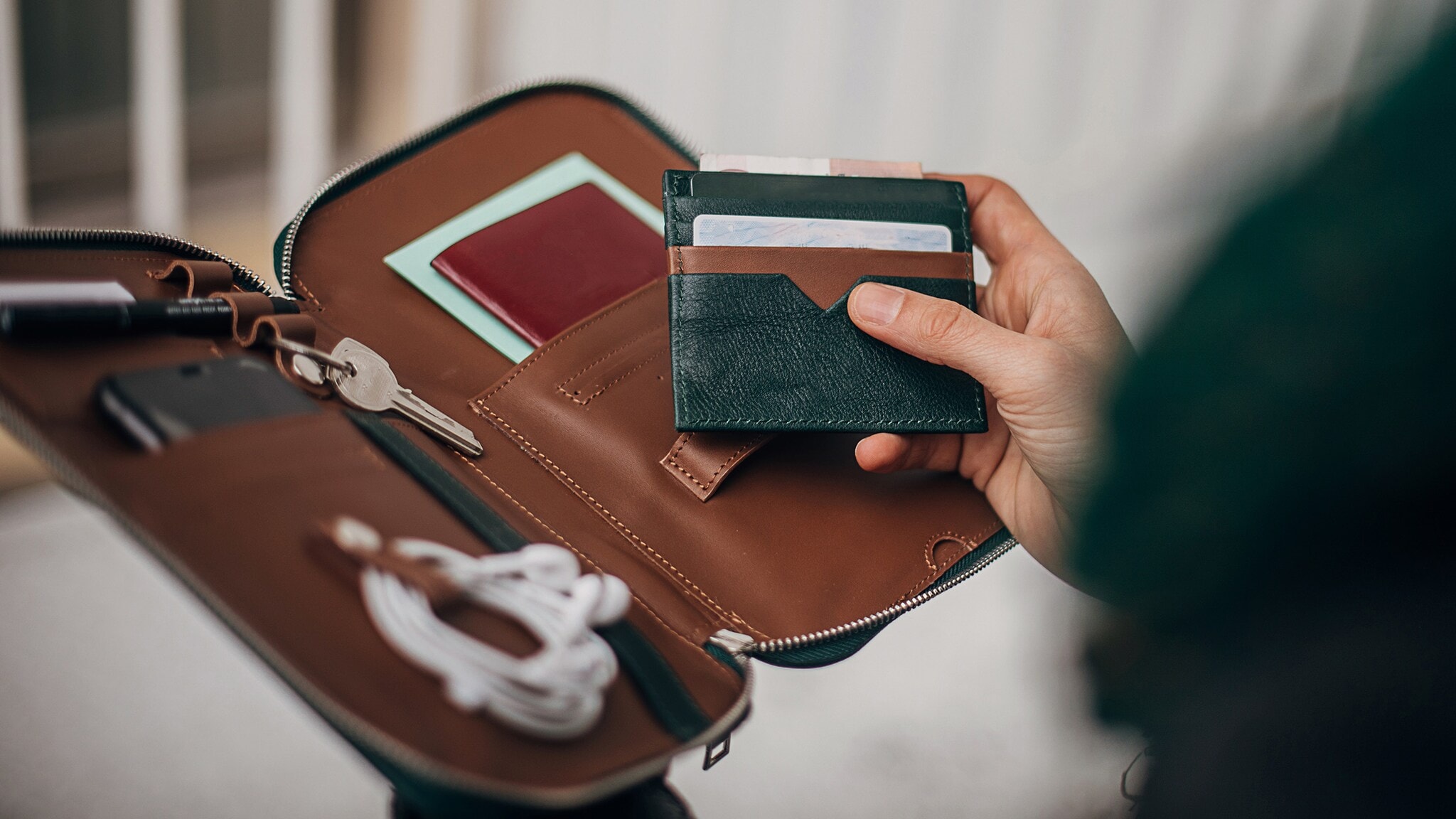 Aufgeklapptes Lederetui mit Kreditkarten, Smartphone und Schlüssel. Aufgeklapptes Lederetui mit Kreditkarten, Smartphone und Schlüssel.