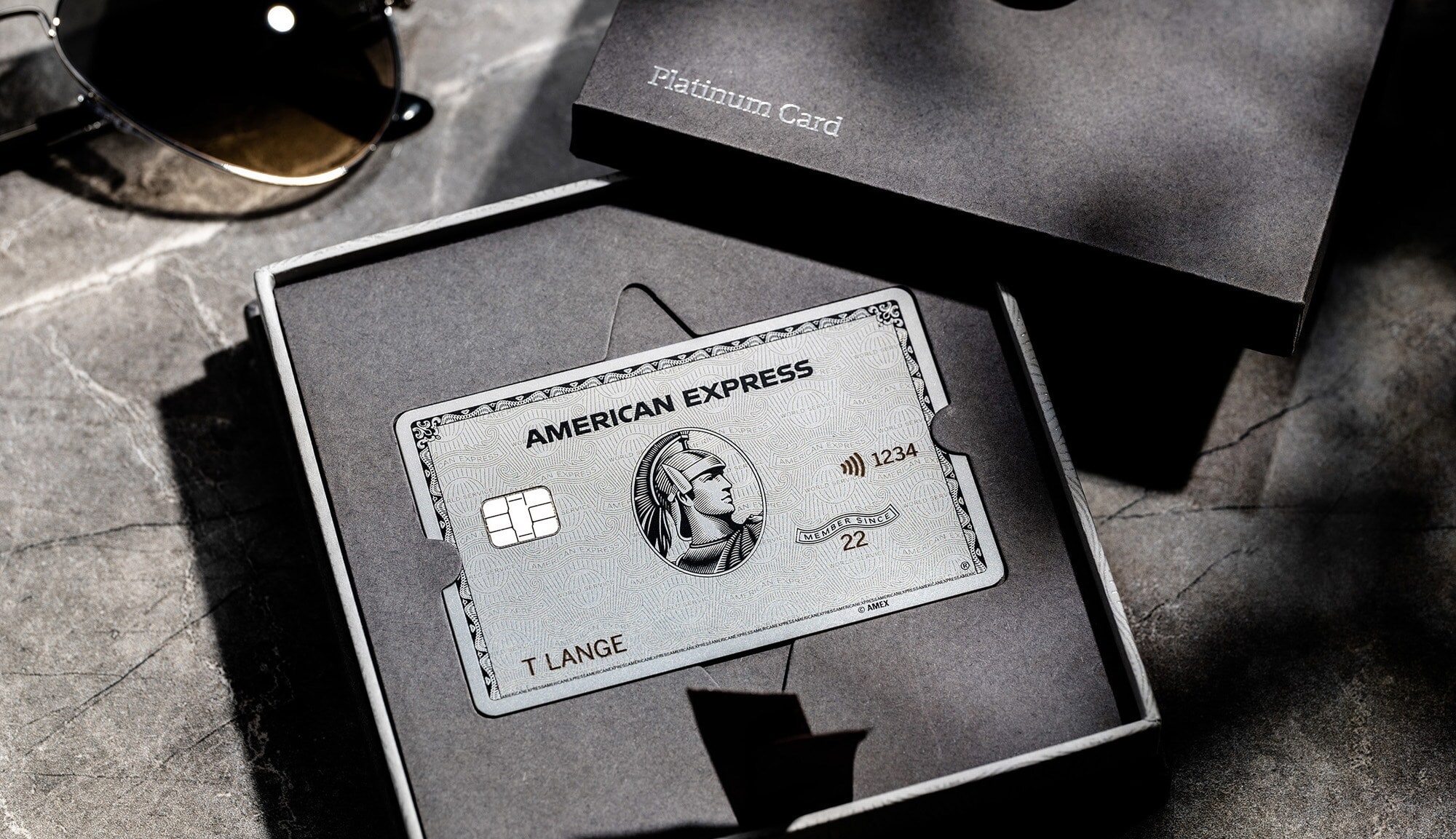 Eine silberne Platinum Kreditkarte von American Express in einer Präsentationsbox aus grauer Kartonage. Eine silberne Platinum Kreditkarte von American Express in einer Präsentationsbox aus grauer Kartonage.