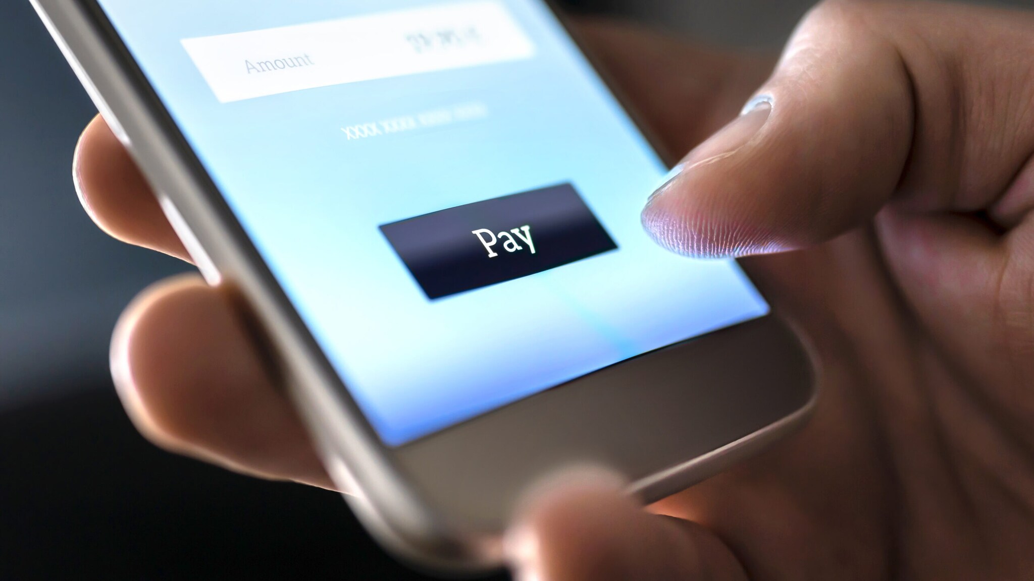 Nahaufnahme einer Hand, die ein Smartphone mit Zahlfunktion auf dem Display bedient