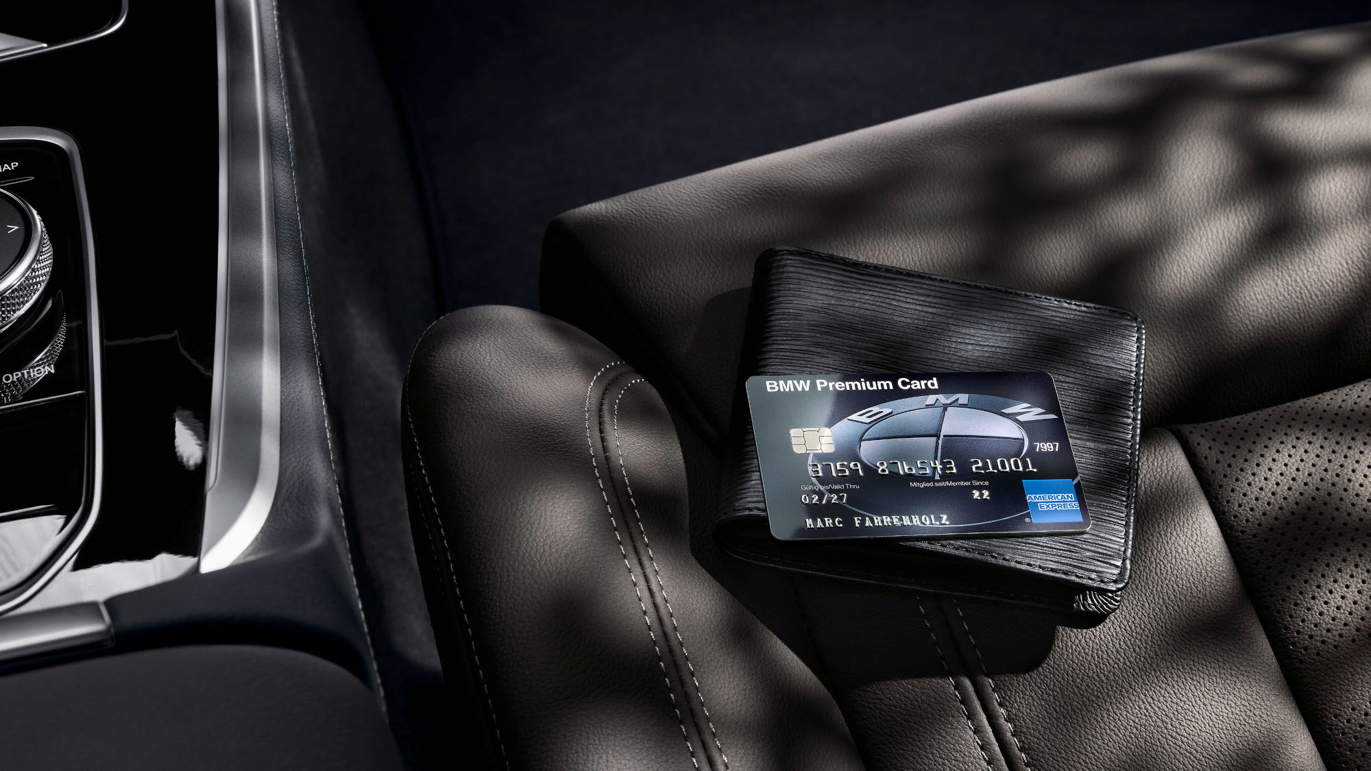 Eine schwarze BMW Premium Card liegt auf einem Schwarzen Portemonnaie auf einem schwarzen Autositz aus Leder. Eine schwarze BMW Premium Card liegt auf einem Schwarzen Portemonnaie auf einem schwarzen Autositz aus Leder.