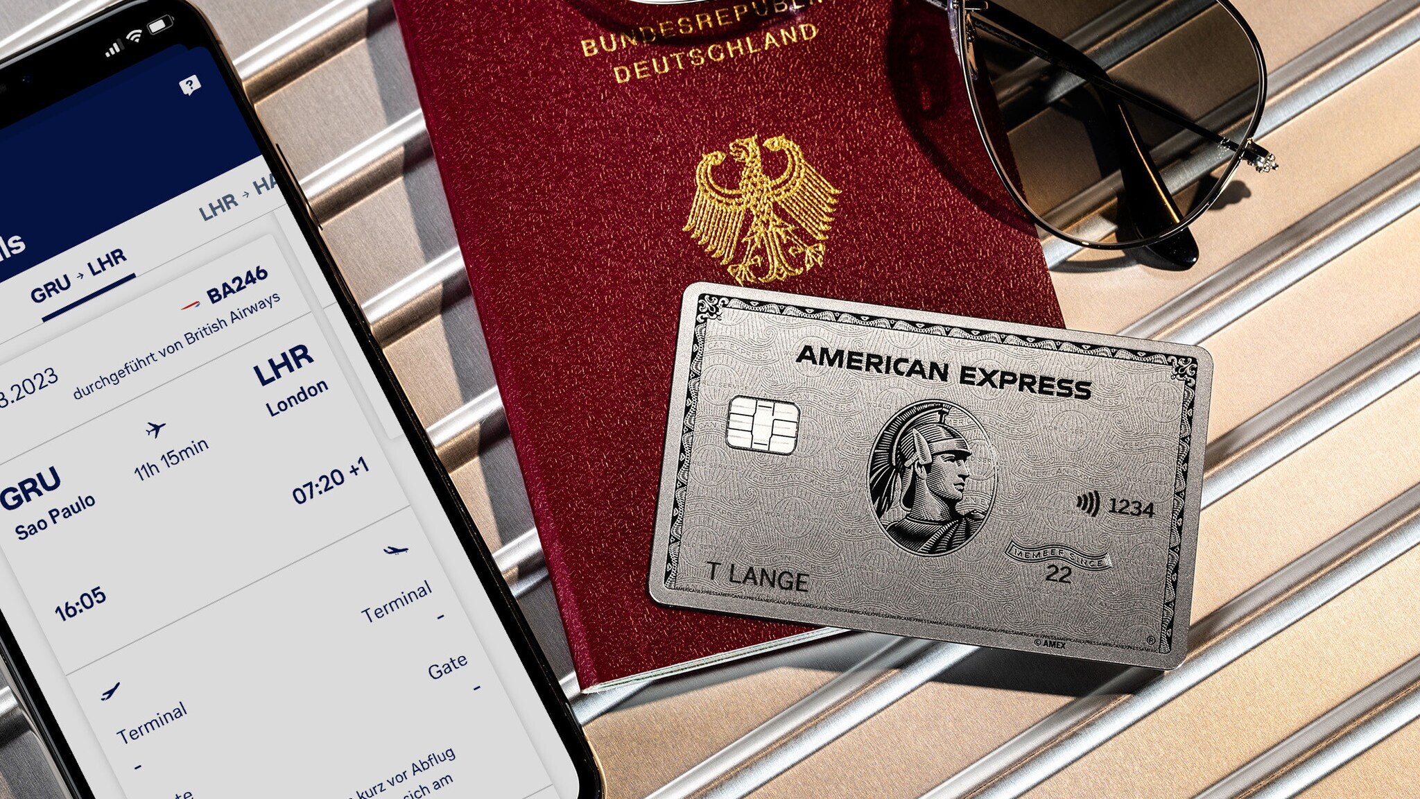 Eine silberne Platinum Kreditkarte von American Express auf einem Reisepass neben einem Smartphone mit Bordkarte auf dem Display. Eine silberne Platinum Kreditkarte von American Express auf einem Reisepass neben einem Smartphone mit Bordkarte auf dem Display.