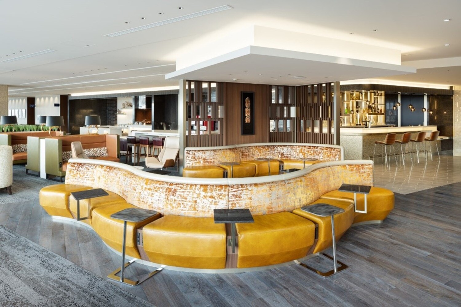 Eine moderne Flughafenlounge mit geschwungenen Sitzinseln vor einer Bar. Eine moderne Flughafenlounge mit geschwungenen Sitzinseln vor einer Bar.