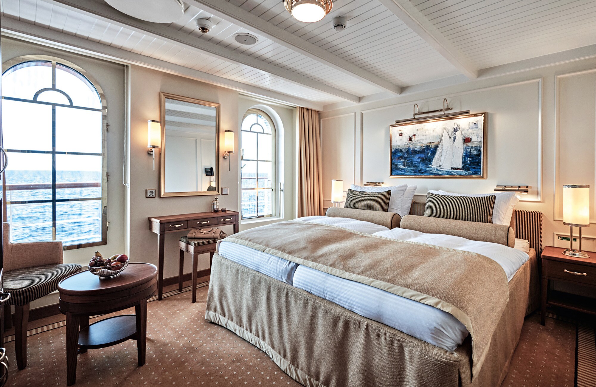 Ein Doppelbett in einer luxuriösen Suite auf einem Schiff mit Blick aufs Meer. Ein Doppelbett in einer luxuriösen Suite auf einem Schiff mit Blick aufs Meer.