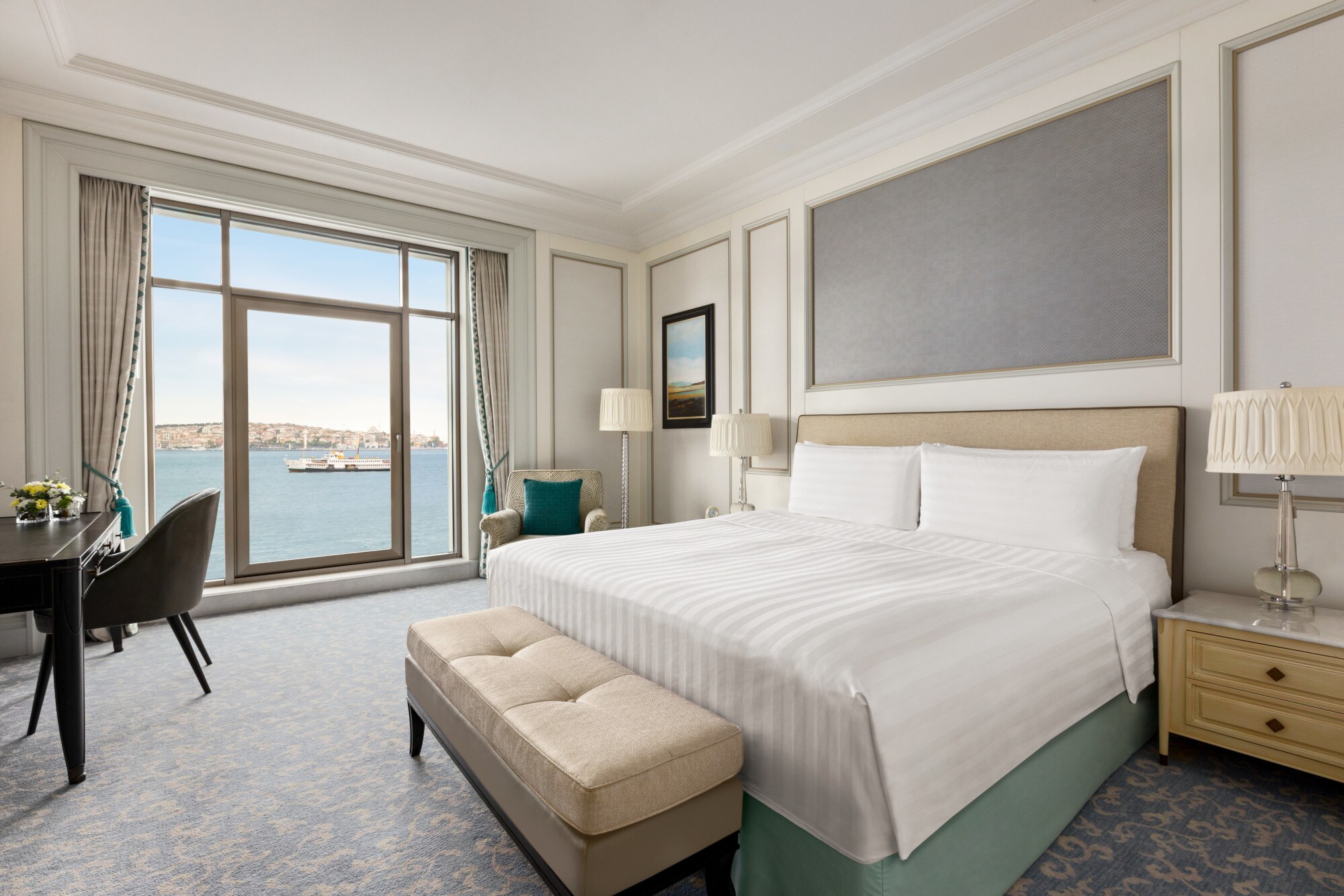 Ein helles Hotelzimmer mit Doppelbett und bodentiefen Fenstern mit Blick auf den Bosporus mit Schiff. Ein helles Hotelzimmer mit Doppelbett und bodentiefen Fenstern mit Blick auf den Bosporus mit Schiff.