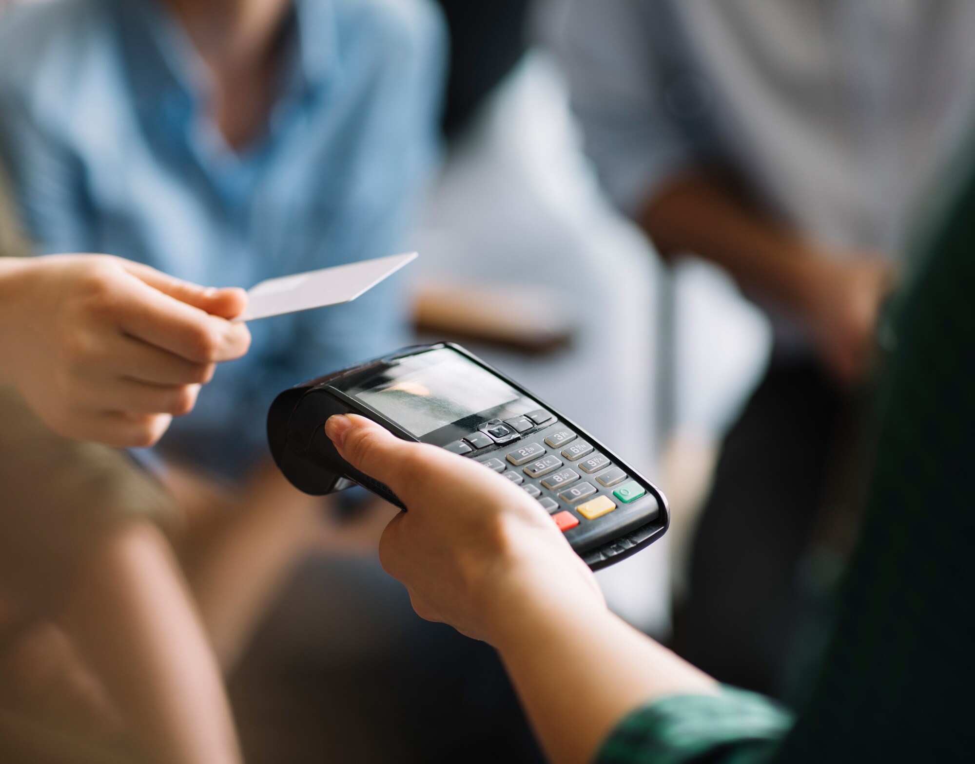 Eine Person bezahlt kontaktlos mit ihrer Kreditkarte.
