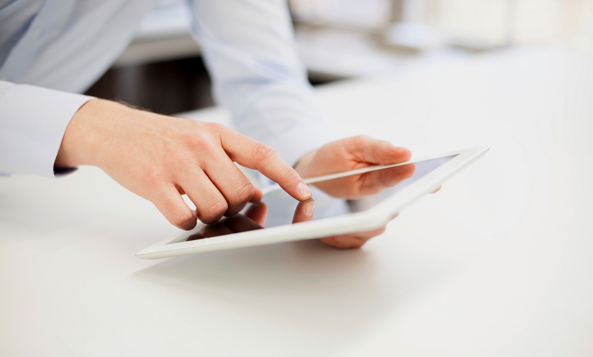 Eine Person bedient ein weißes Tablet in ihrer Hand