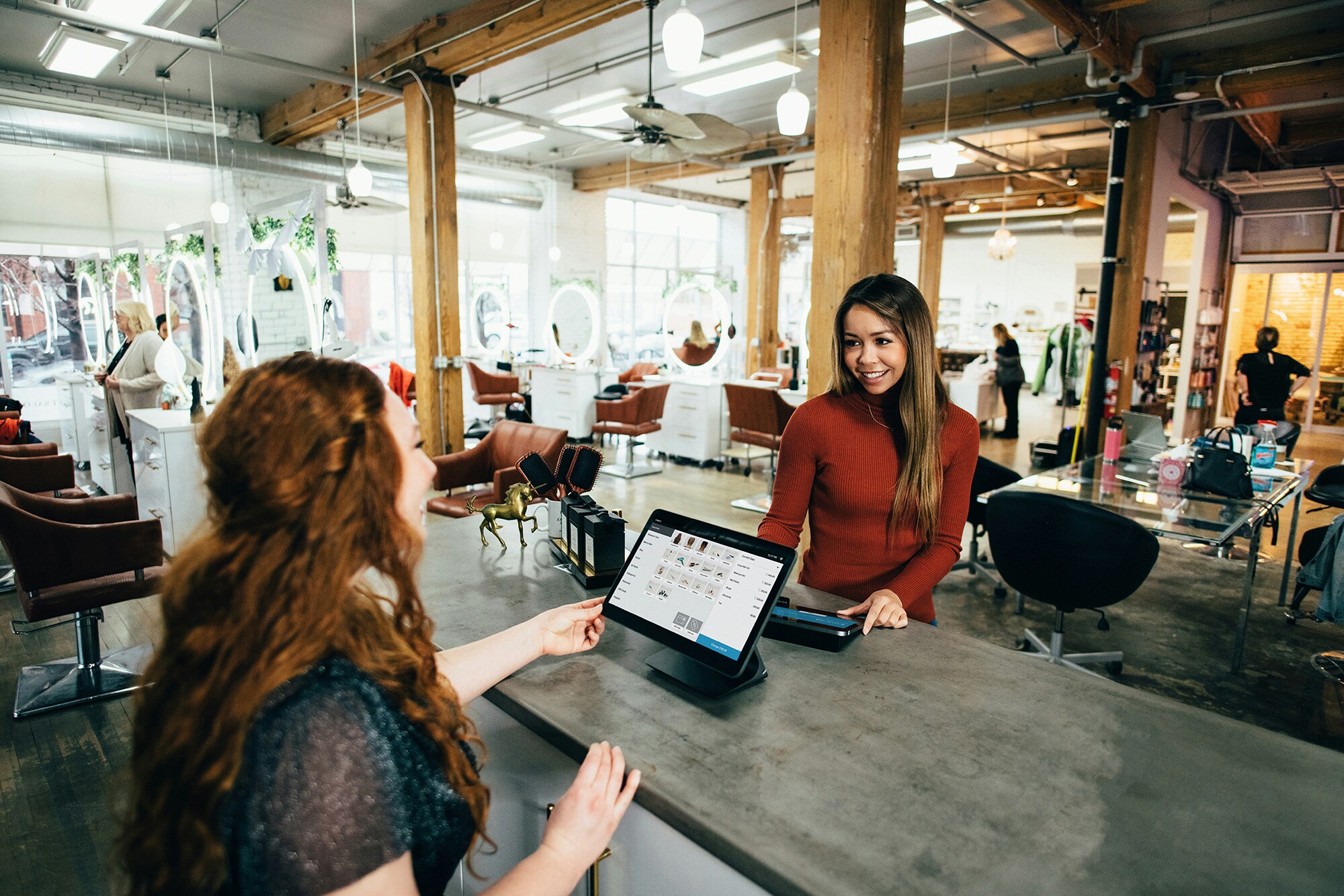 Amex Akzeptanz – die Vorteile für dein Business im Überblick Eine Frau bezahlt im Beautysalon mit Karte.