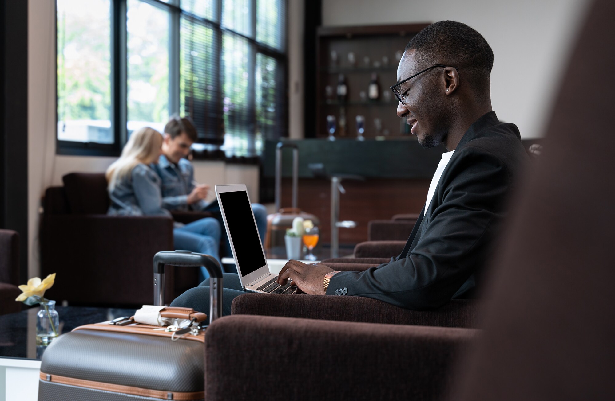 Ein Geschäftsmann arbeitet in Hotellobby am Laptop.