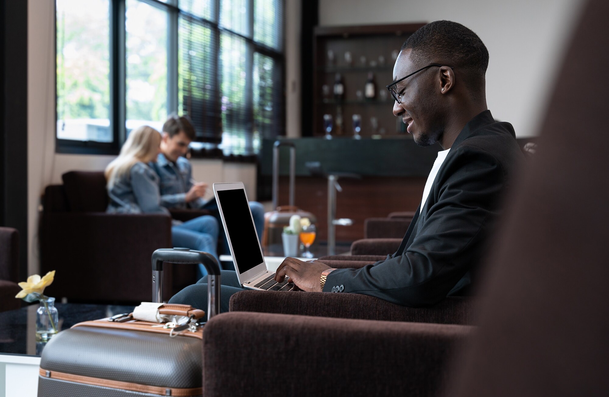 Basic Guide: So sammelst du jetzt noch mehr Membership Rewards® Punkte Ein Geschäftsmann arbeitet in Hotellobby am Laptop.