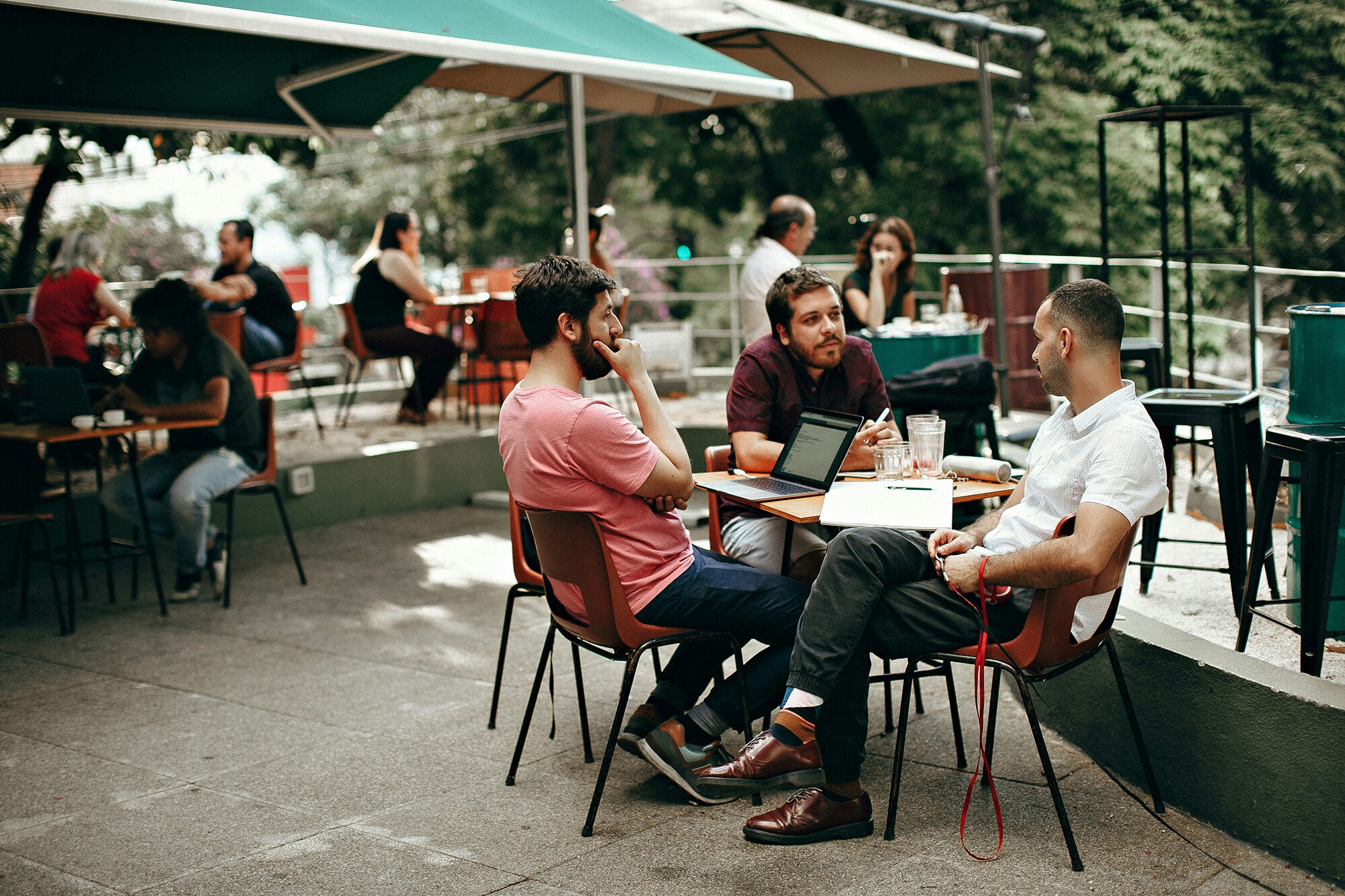 Mit Amex zu einem besseren Schutz vor Online-Betrug Drei junge Leute arbeiten zusammen in Café.