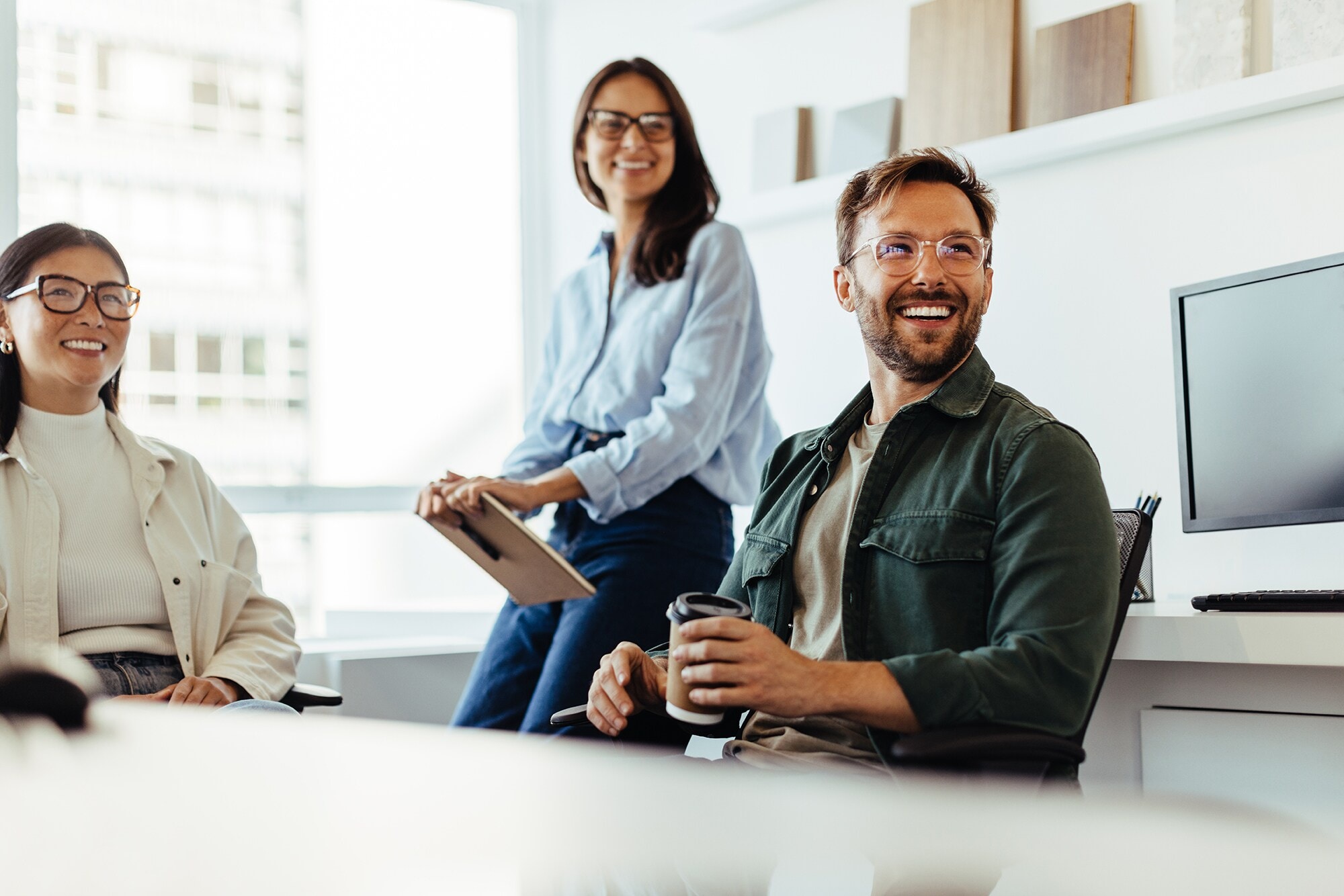 Amex Zusatzkarten: Die Vorteile für dich & dein Team Ein Business-Team hat ein Meeting in lockerer Atmosphäre.