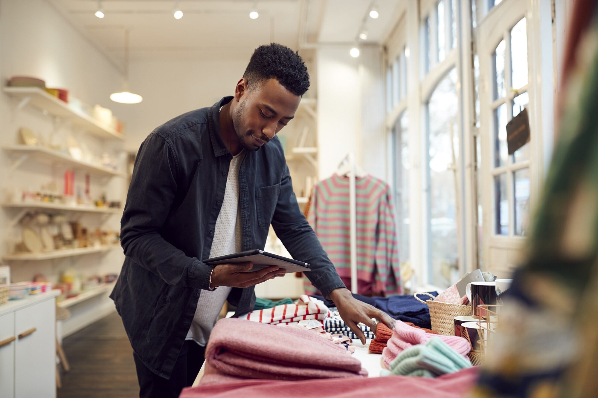 Shop Small: mehr Vielfalt für deine Kundschaft, mehr Vorteile für dich Ein Geschäftsinhaber prüft die Ware und benutzt dazu ein Tablet.