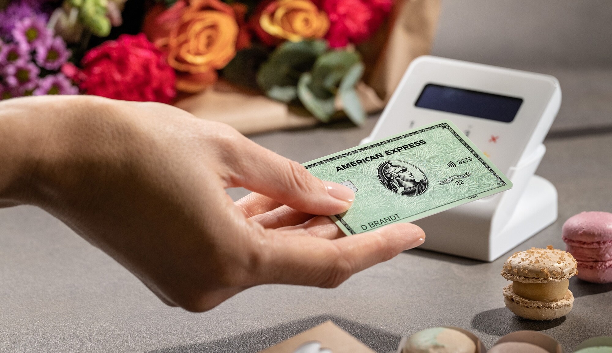 Kontaktlose Zahlung mit einer grünen American Express Kreditkarte an einem Kartenlesegerät. Kontaktlose Zahlung mit einer grünen American Express Kreditkarte an einem Kartenlesegerät.