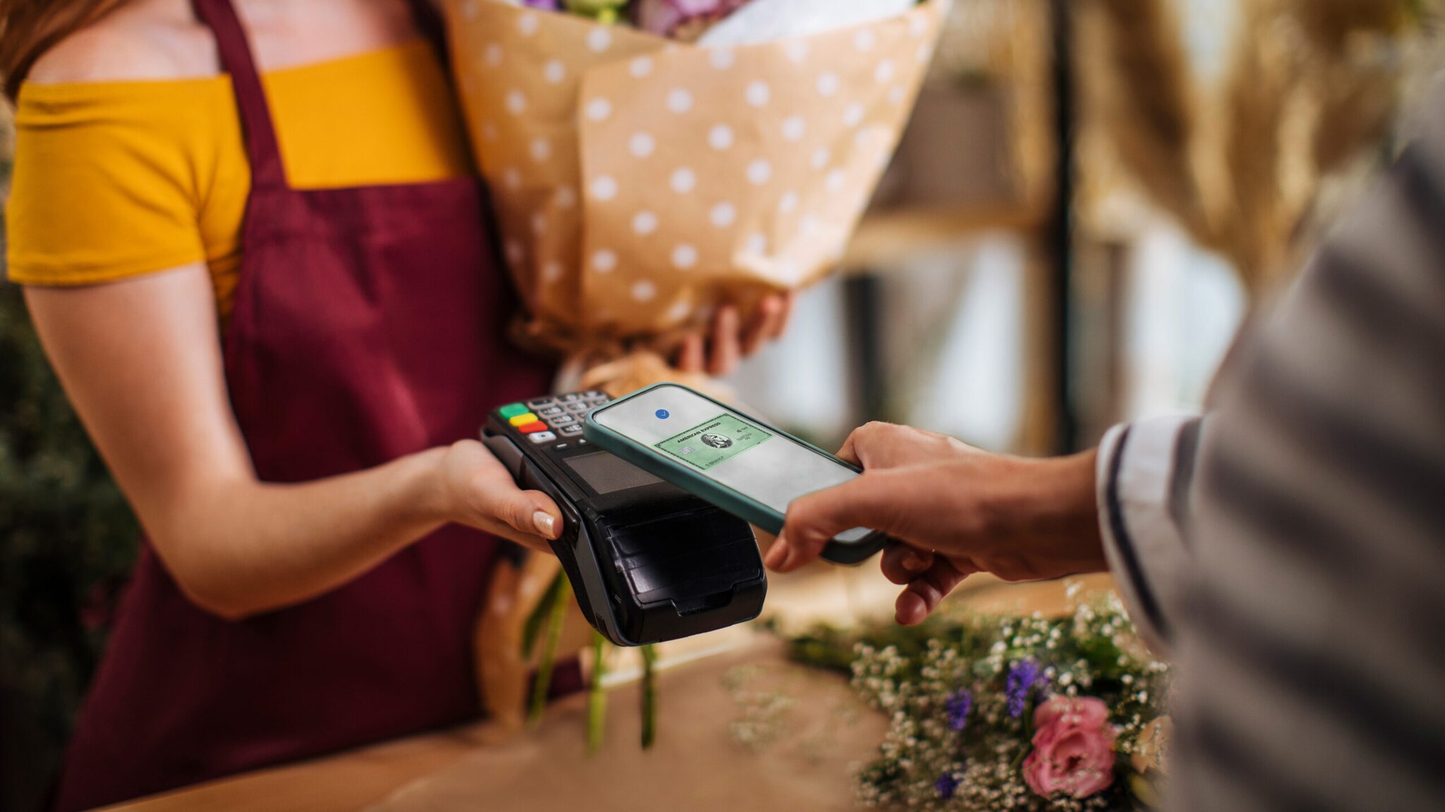 Kontaktlose Zahlung mit American Express Kreditkarte per Smartphone in einer Boutique Kontaktlose Zahlung mit American Express Kreditkarte per Smartphone in einer Boutique