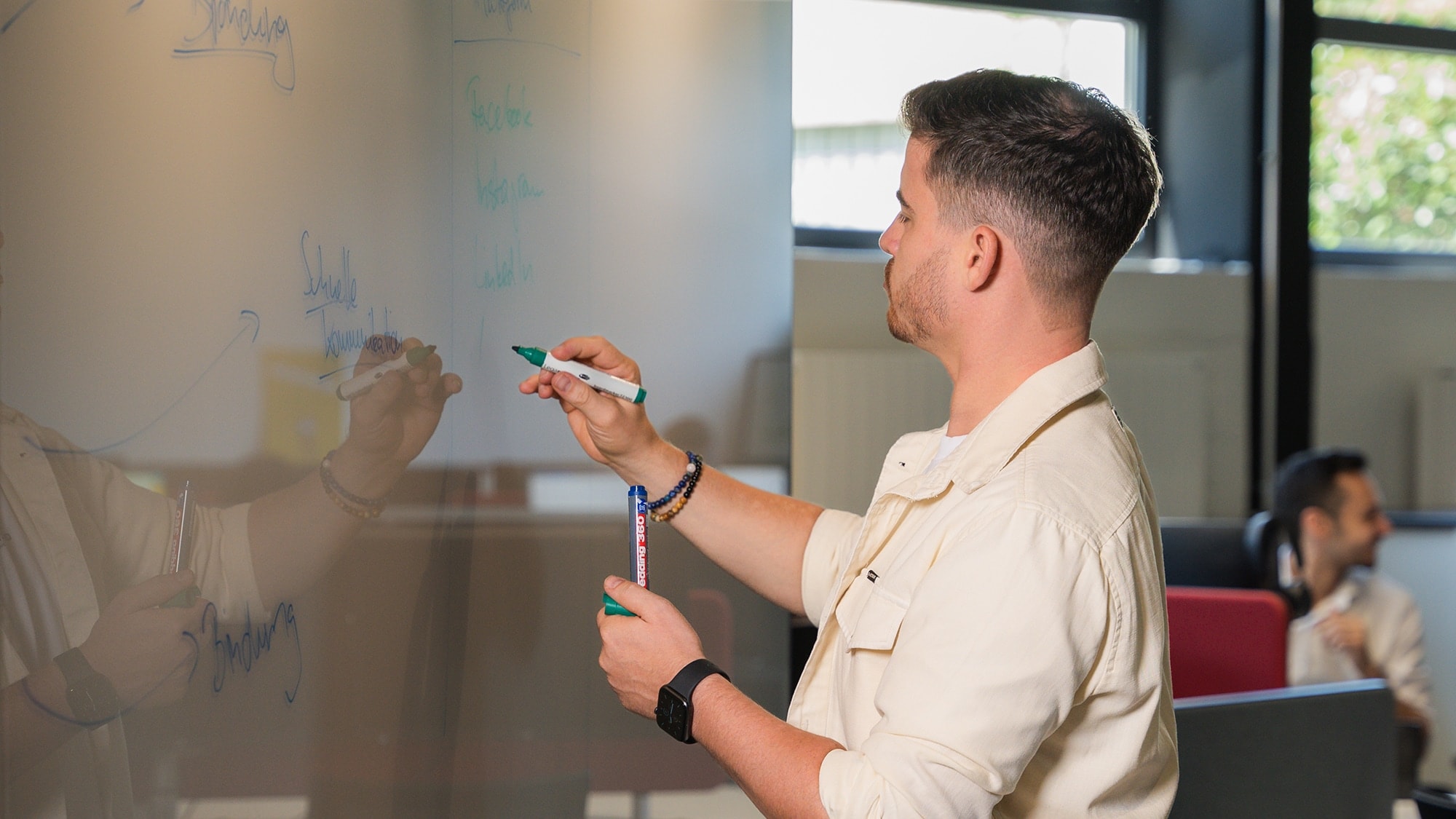 24h Business Platinum: Ein Tag im Leben von Adstark-Gründer Ruslan Ilyassov Adstark-Gründer Ruslan Ilyassov schreibt an einem Whiteboard.