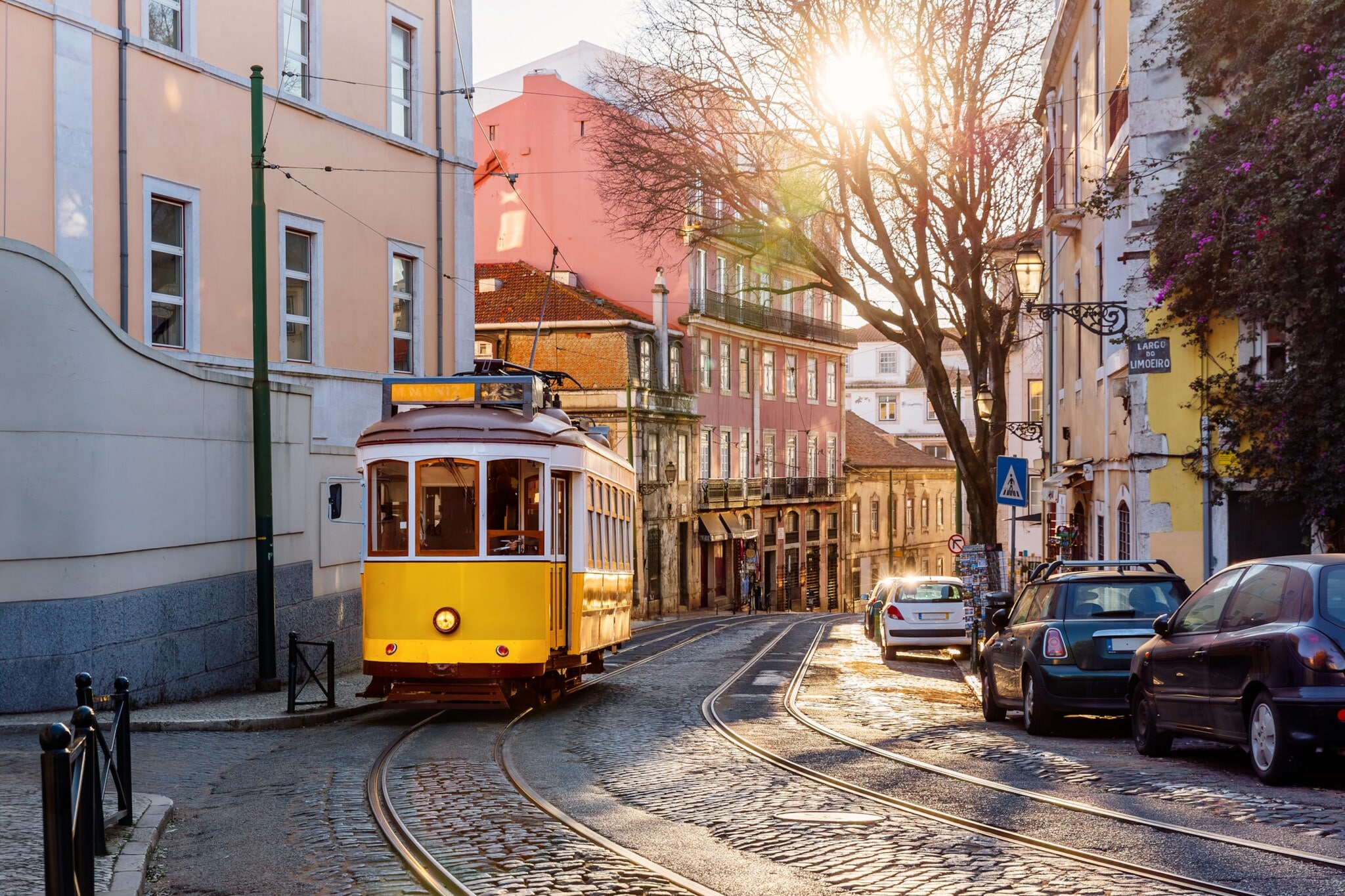 Gelbe Straßenbahn auf einer Straße mit Kopfsteinpflaster im Stadtzentrum.