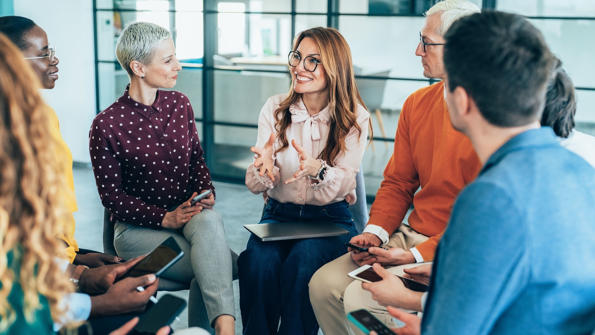 Mehrere Personen mit digitalen Endgeräten in den Händen sitzen im Stuhlkreis und besprechen etwas. Mehrere Personen mit digitalen Endgeräten in den Händen sitzen im Stuhlkreis und besprechen etwas.