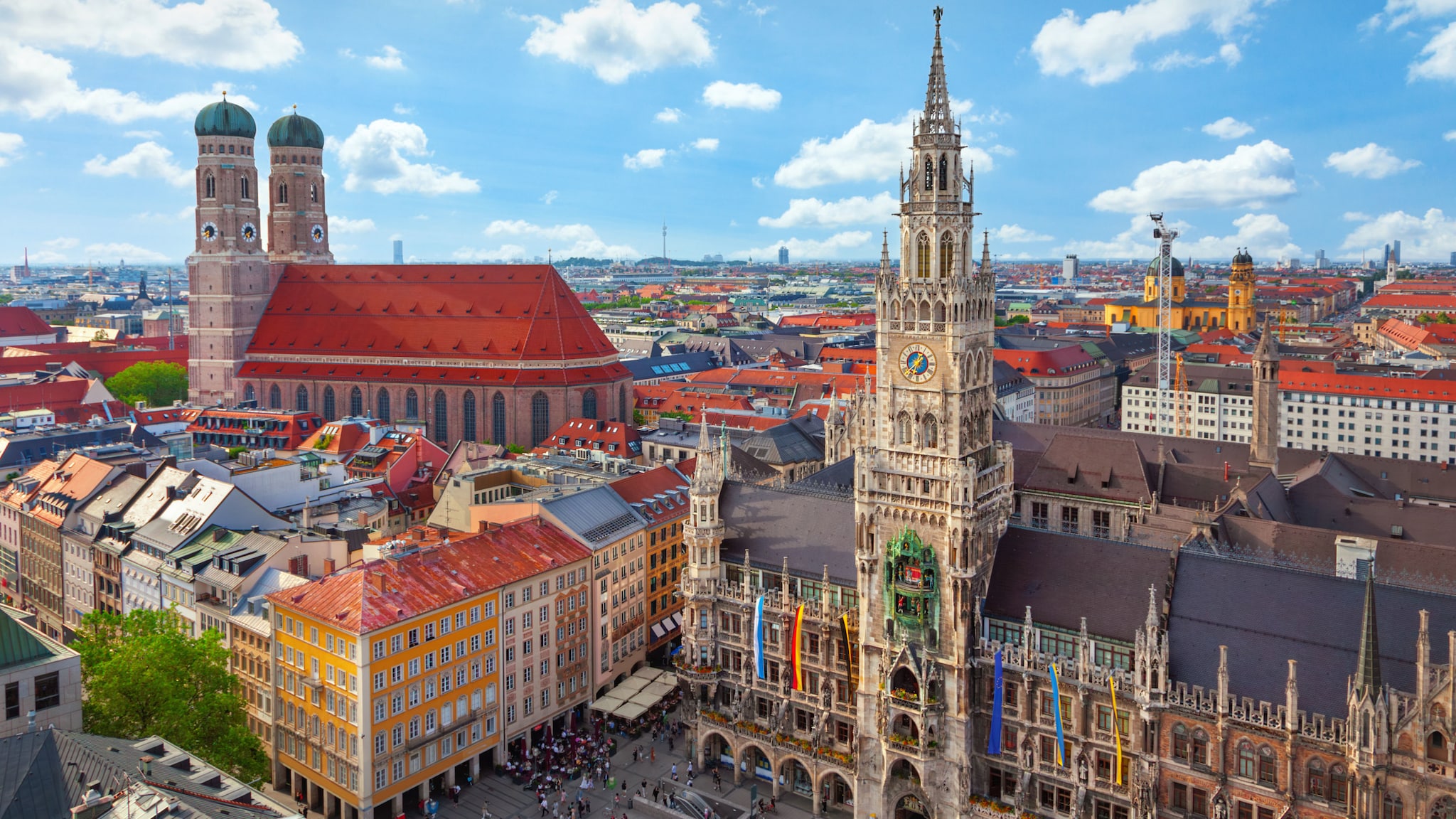 Aufsicht Altstadtpanorama von München mit Rathaus und Kirche unter blauem Himmel mit kleinen Wolken.