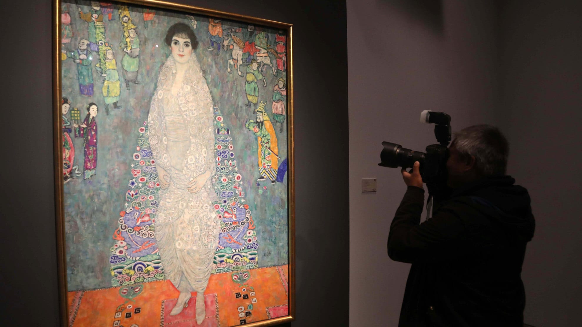 Ein Fotograf steh vor Gustav Klimts großformatigem Bild „Bildnis Elisabeth Lederer“, das an einer dunklen Wand hängt.