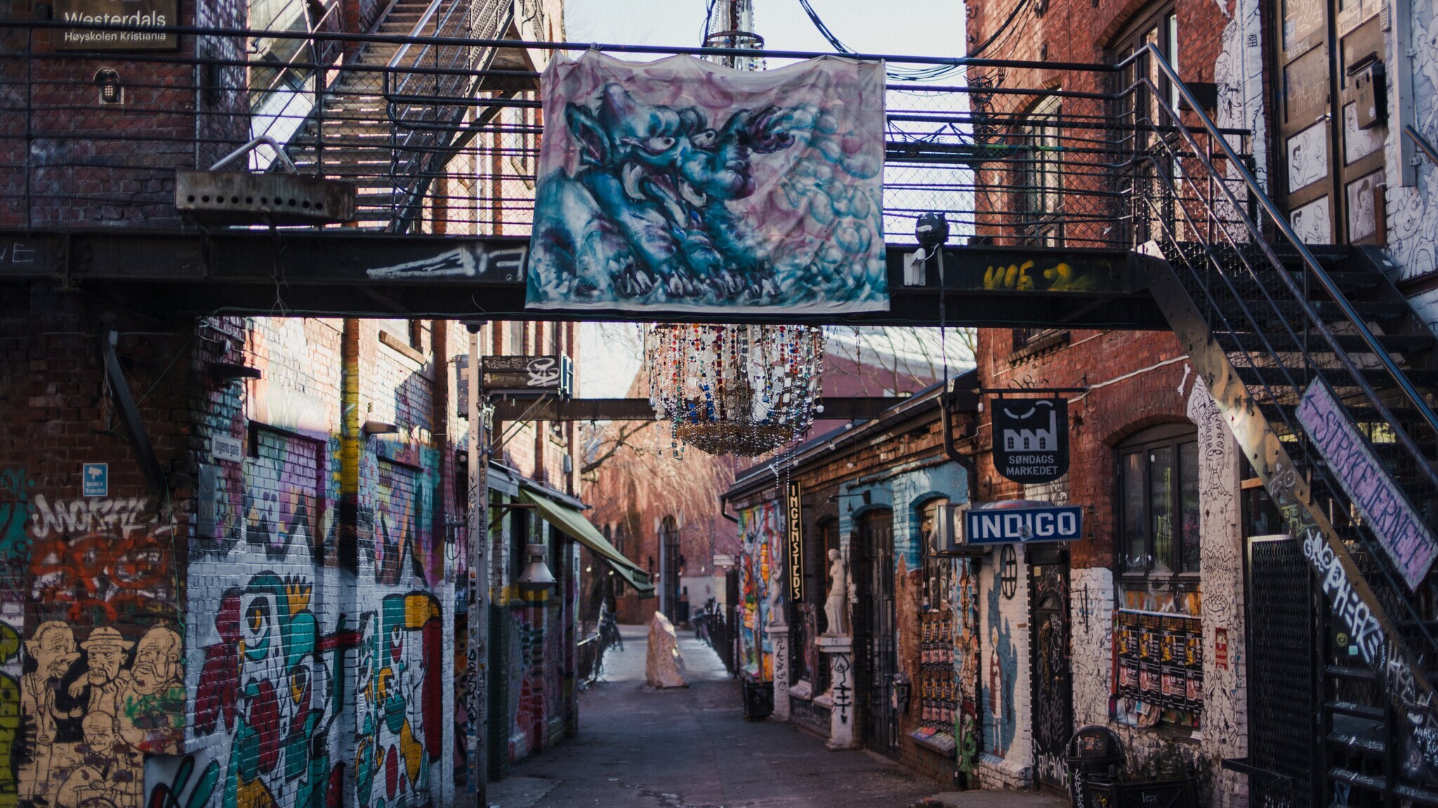 In einer Straße sind Wände und Mauern der Gebäude mit Graffitis bemalt.