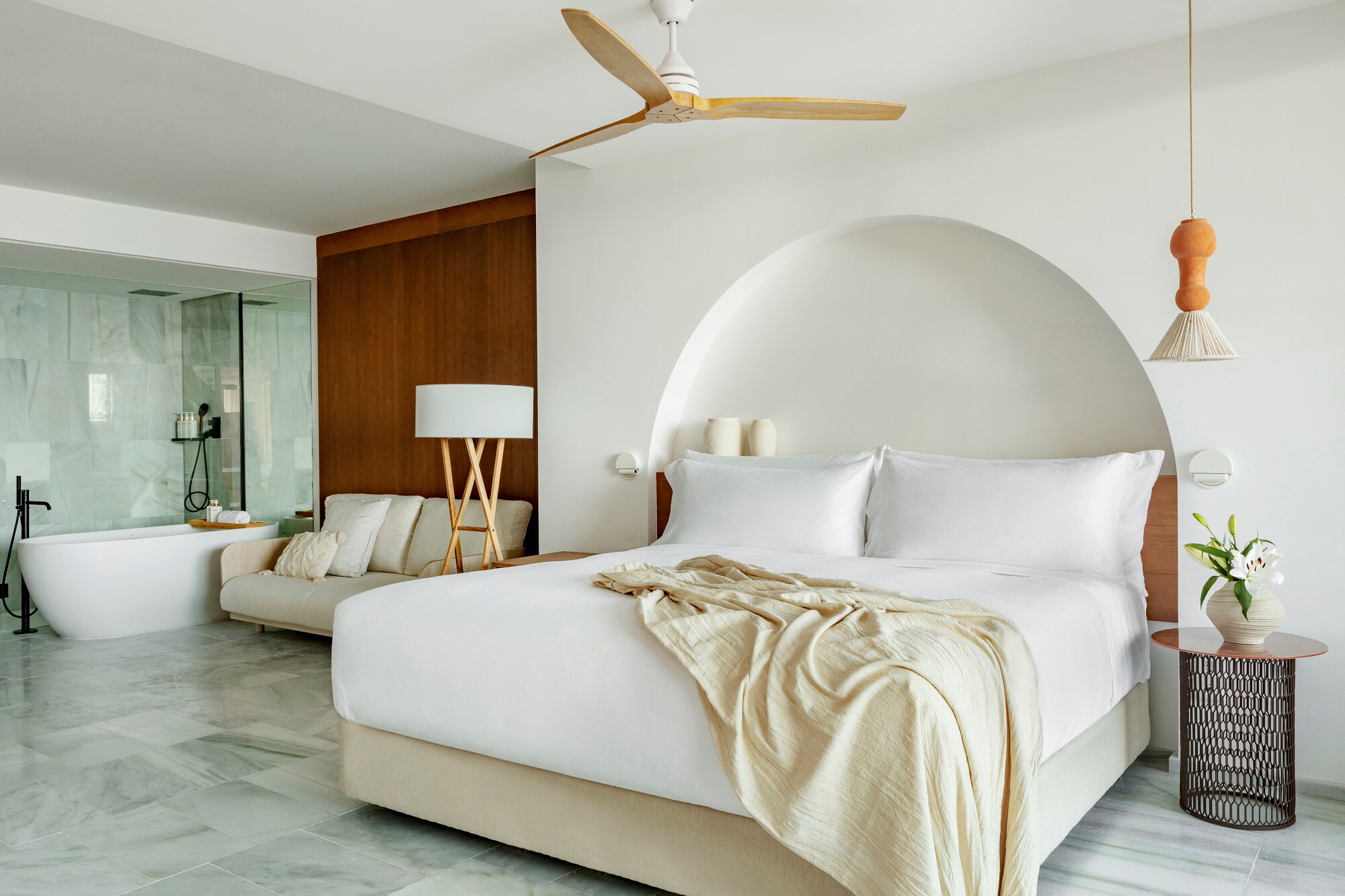 Eine moderne Hotelsuite in hellen Tönen mit Doppelbett und Badewanne. Eine moderne Hotelsuite in hellen Tönen mit Doppelbett und Badewanne.