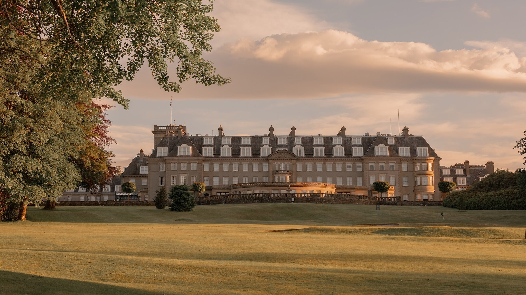 Ein luxuriöses Schlosshotel mit weitläufiger Rasenfläche in der Natur.