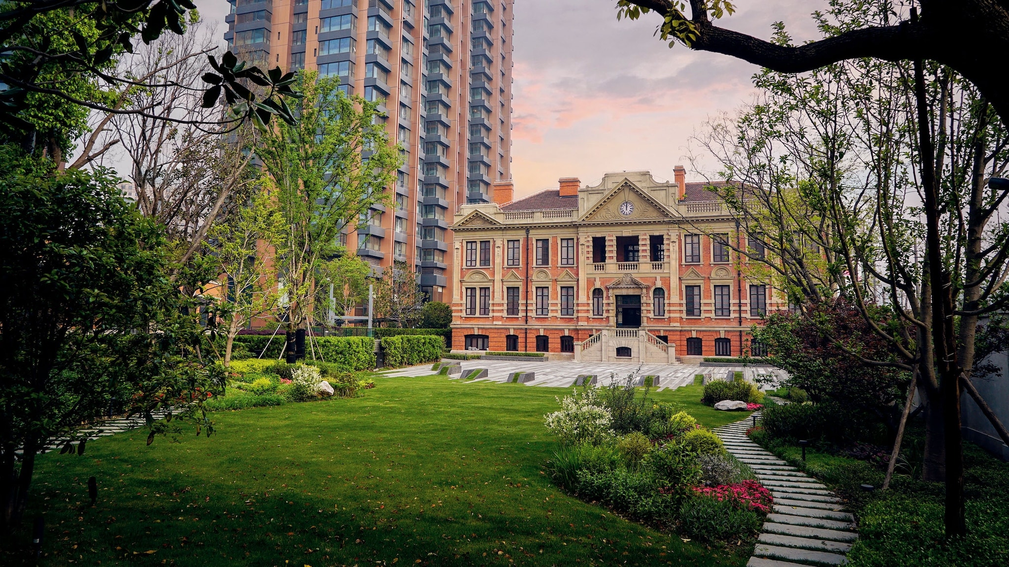 amex-magazin-bulgari-hotel-shanghai Hotelanlage mit historischem Gebäude neben einem Hochhaus in einer Gartenanlage.