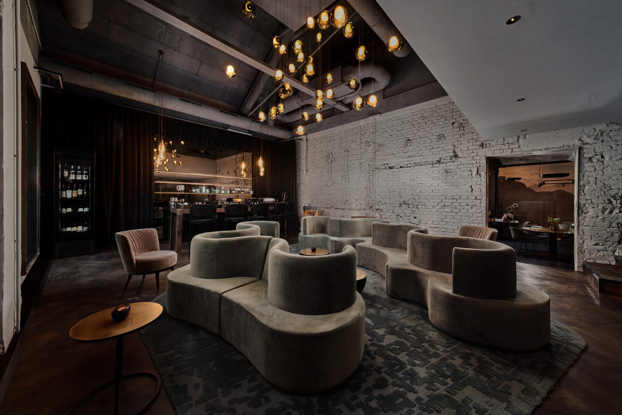 Gastraum in edlem Design, mit geschwungenen Polstermöbeln und einem Ambiente in Industriestil.