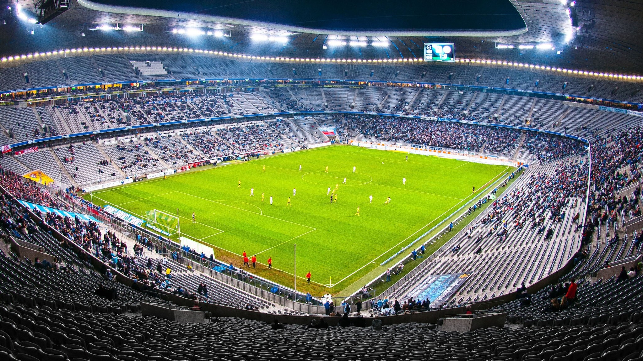 Blick auf ein Fußballfeld mit Spielern von der Tribüne im Inneren eines Fußballstadions. Blick auf ein Fußballfeld mit Spielern von der Tribüne im Inneren eines Fußballstadions.