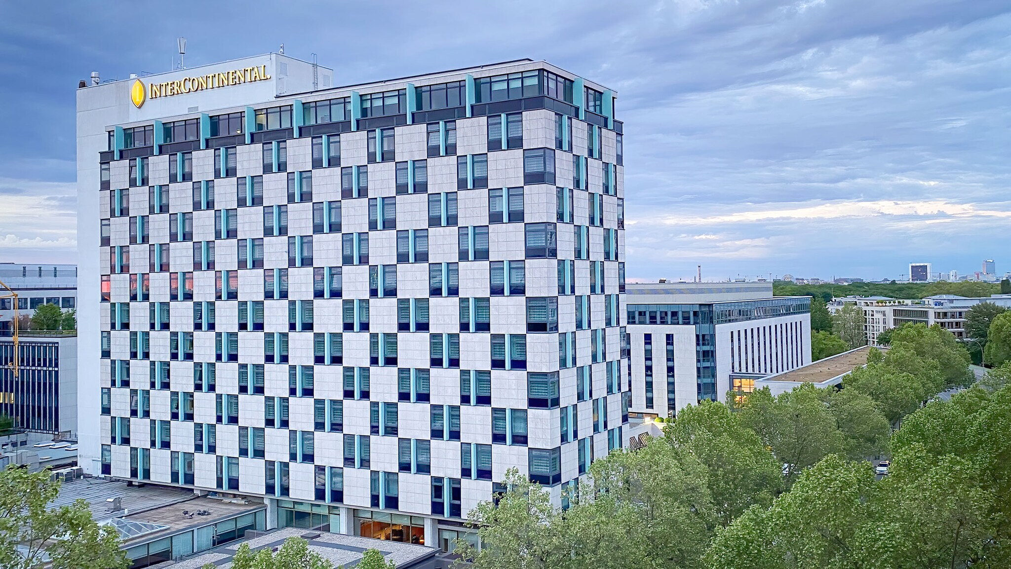Außenansicht eines Hochhauses mit Schachbrettfassade und Intercontinental-Logotype in urbaner Umgebung.