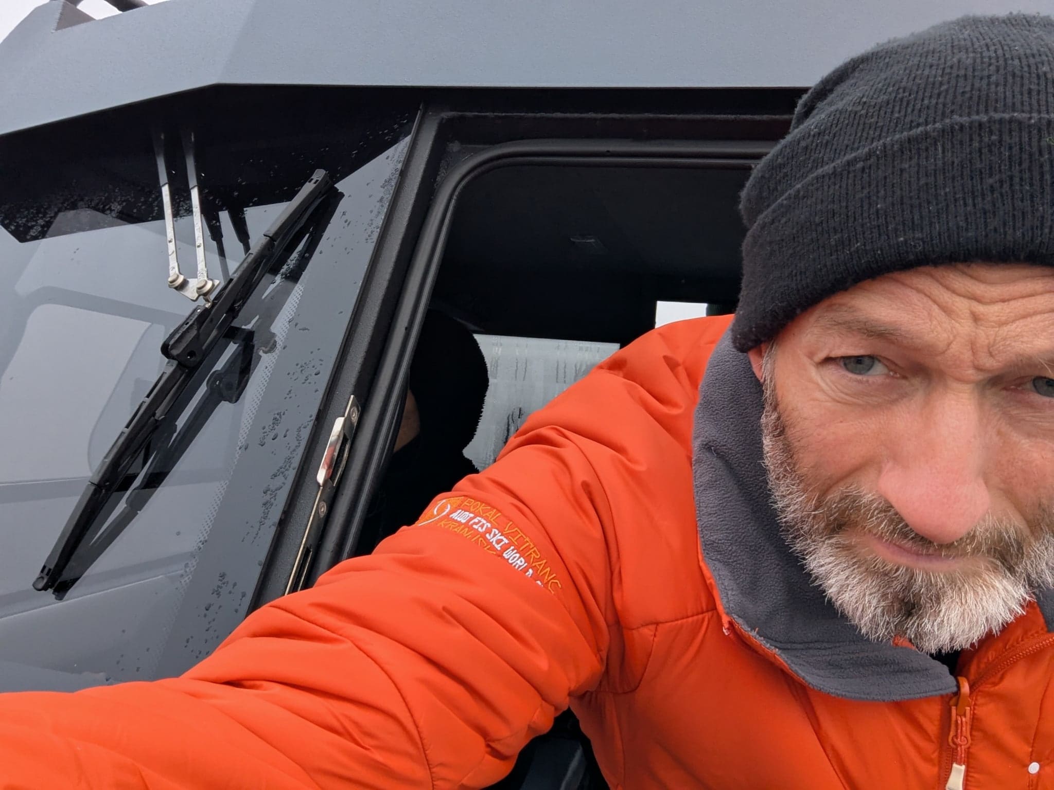 Person mit wetterfester Kleidung im Steuerhaus eines Motorboots mit regennassen Scheiben. Person mit wetterfester Kleidung im Steuerhaus eines Motorboots mit regennassen Scheiben.