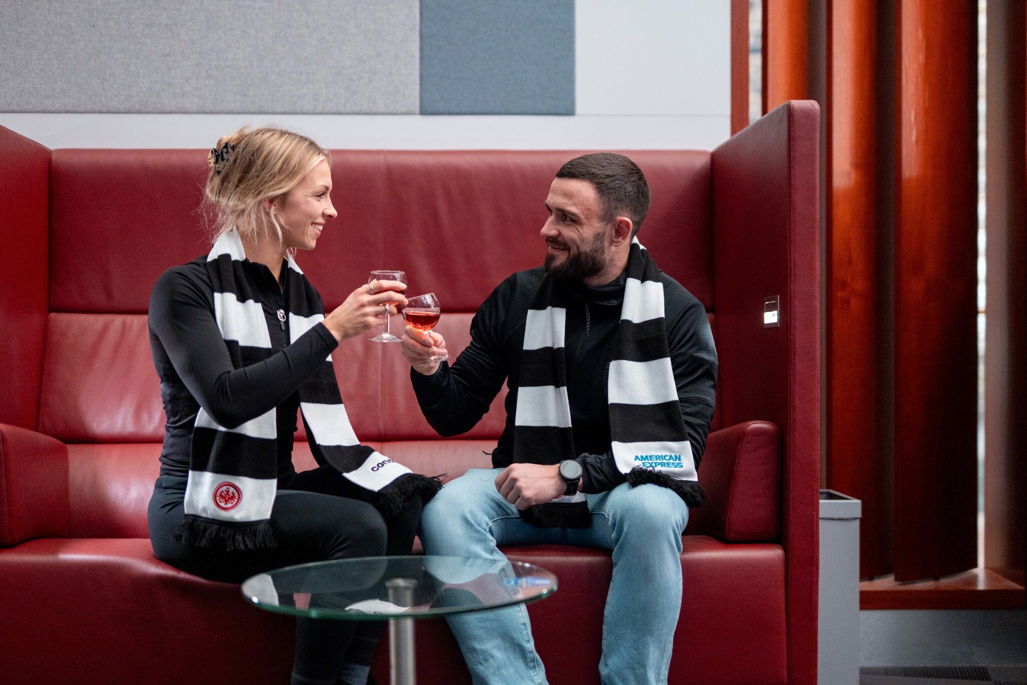 Ein Paar mit Weingläsern in der Hand prostet sich zu.