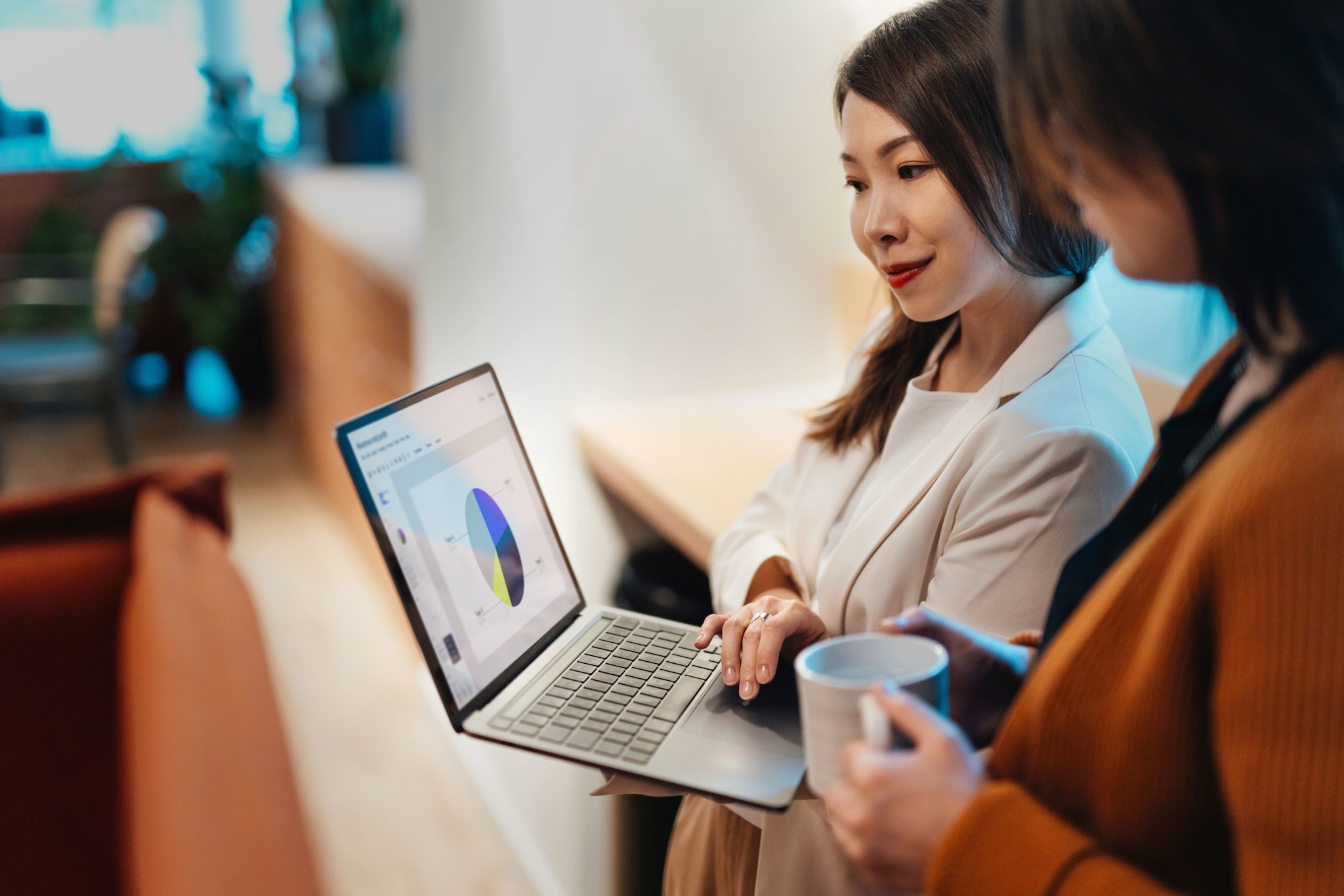 Zwei Frauen schauen gemeinsam auf einen Laptop, dessen Bildschirm ein Tortendiagramm zeigt. Zwei Frauen schauen gemeinsam auf einen Laptop, dessen Bildschirm ein Tortendiagramm zeigt.