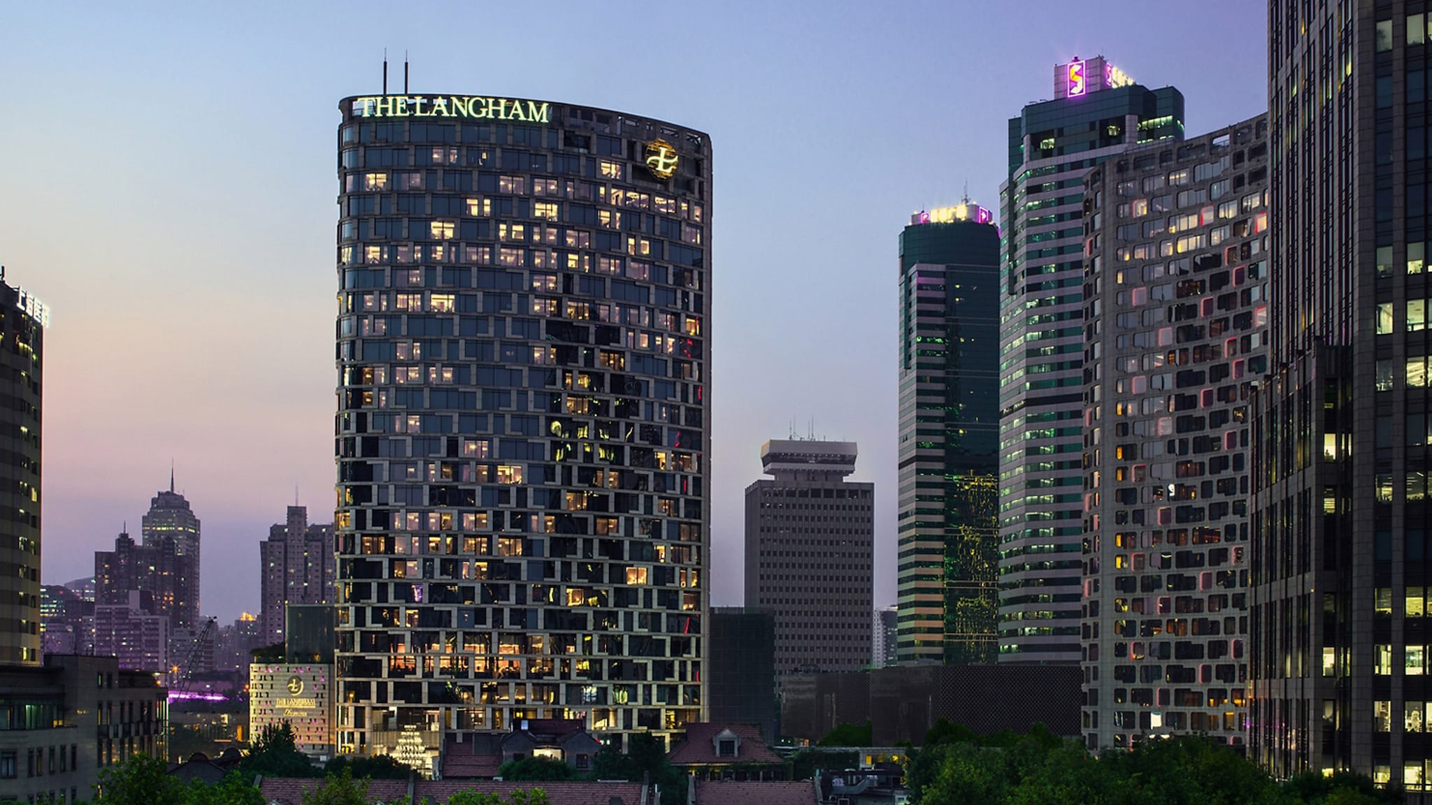 Beleuchtete Skyline mit Wolkenkratzern bei Abenddämmerung.